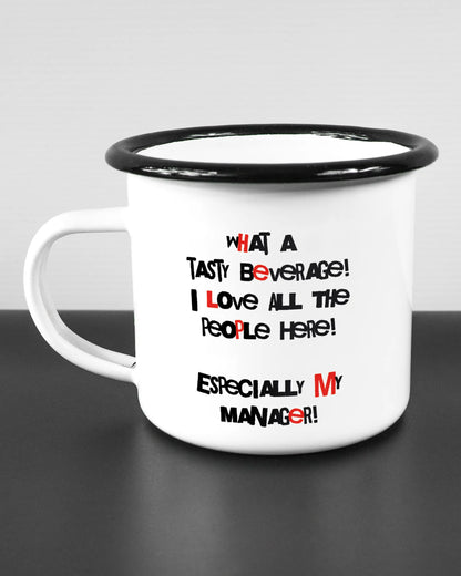 Titelbild, das die linke Seite der beidseitig bedruckten Emailletasse von Maondo mit dem Design Help me in der Farbe White-Black auf einem Holztisch zeigt