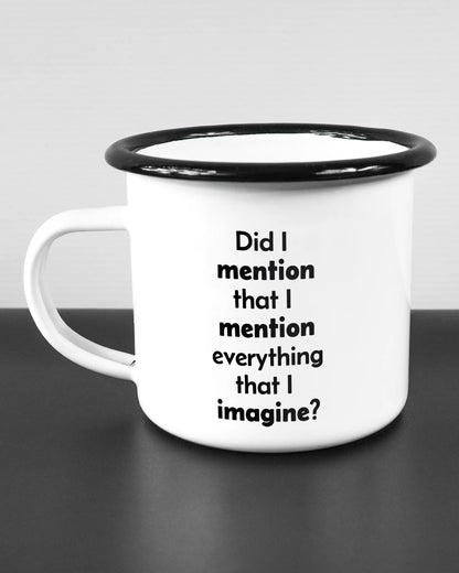 Titelbild, das die linke Seite der beidseitig bedruckten Emailletasse von Maondo mit dem Design Did I mention in der Farbe White-Black auf einem Holztisch zeigt