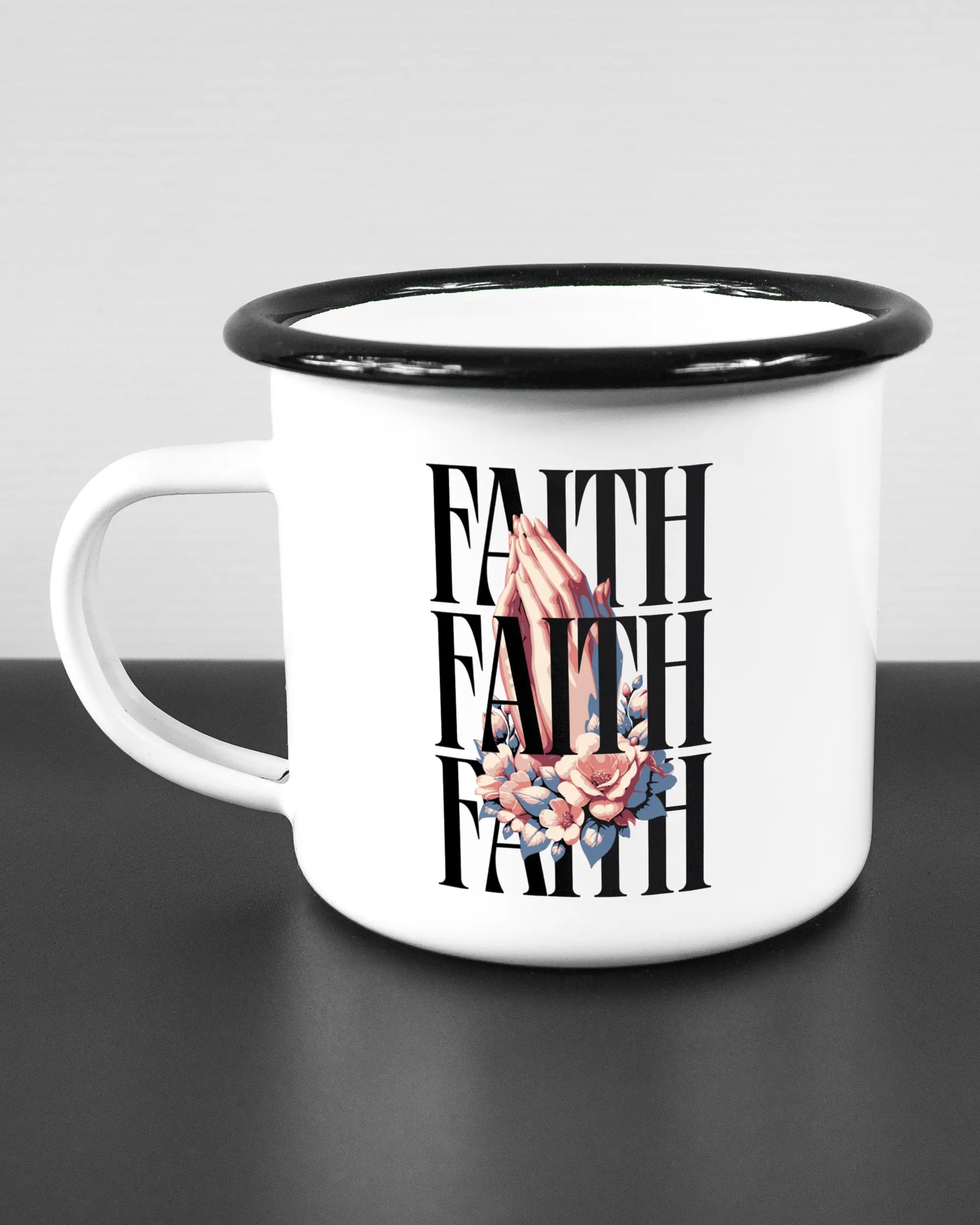 Titelbild, das die linke Seite der beidseitig bedruckten Emailletasse von Maondo mit dem Design Faith X3 in der Farbe White-Black auf einem Holztisch zeigt