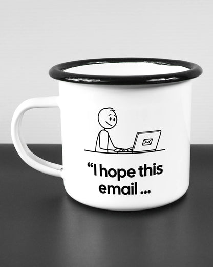 Titelbild, das die linke Seite der beidseitig bedruckten Emailletasse von Maondo mit dem Design Found me not well in der Farbe White-Black auf einem Holztisch zeigt