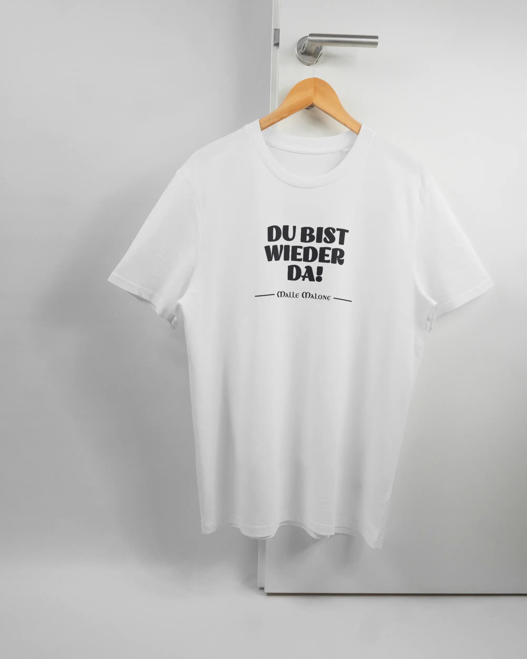 Vorderseite des Organic Unisex T-Shirt Casual von Maondo mit dem Design Wieder da in der Farbe White und in der Größe L auf einem Bügel an der Türklinke aufgehängt