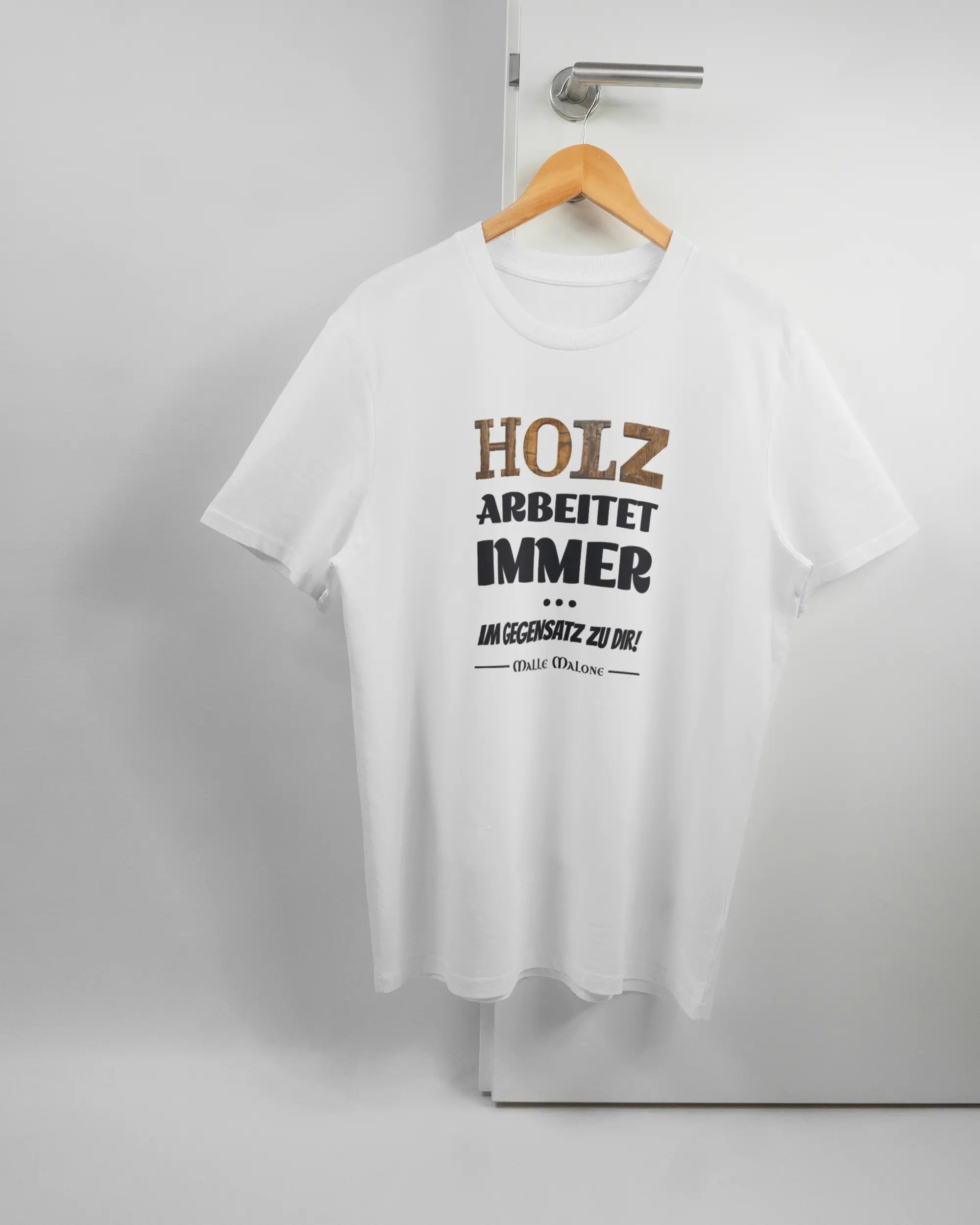 Vorderseite des Organic Unisex T-Shirt Casual von Maondo mit dem Design Holzarbeit in der Farbe White und in der Größe L auf einem Bügel an der Türklinke aufgehängt