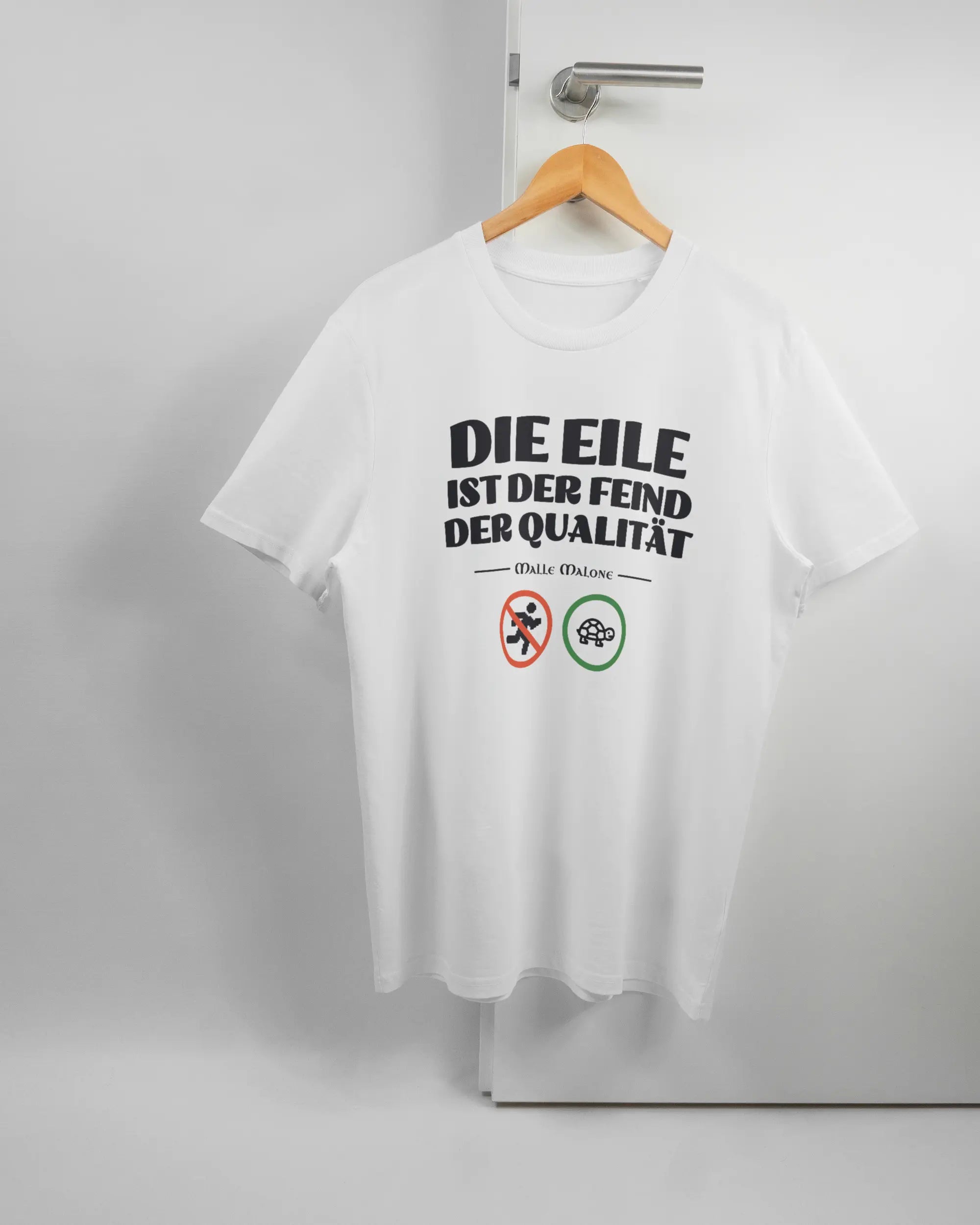 Vorderseite des Organic Unisex T-Shirt Casual von Maondo mit dem Design Keine Eile in der Farbe White und in der Größe L auf einem Bügel an der Türklinke aufgehängt