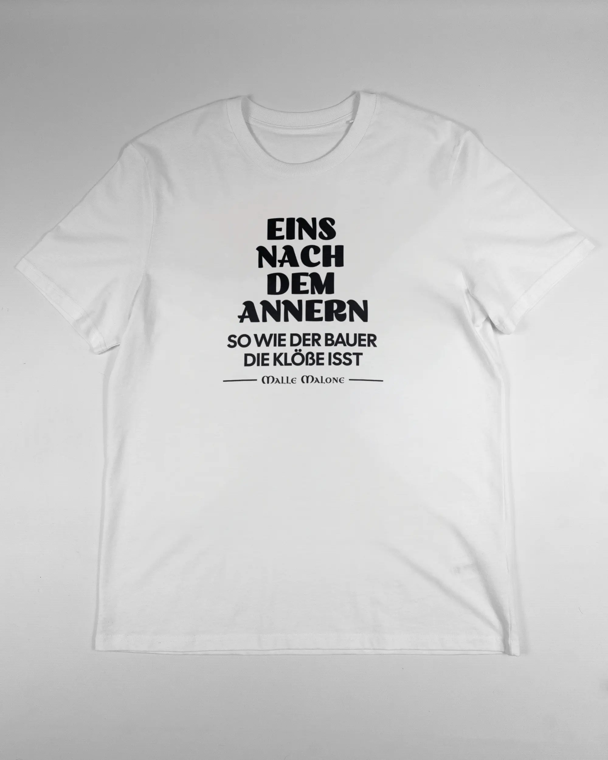 Vorderseite des Organic Unisex T-Shirt Casual von Maondo mit dem Design Eins nach dem Annern in der Farbe White und in der Größe L flach auf den Boden gelegt