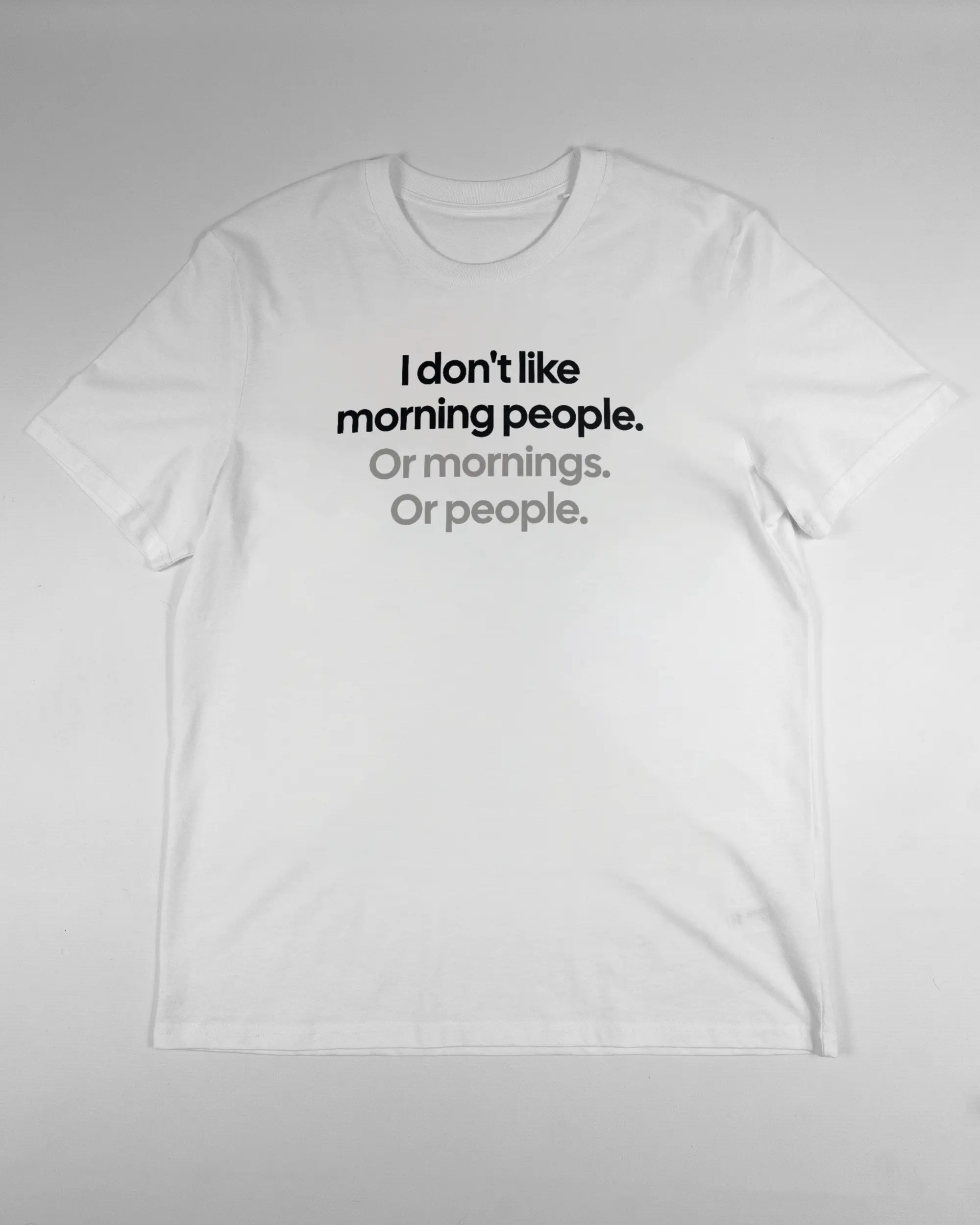 Vorderseite des Organic Unisex T-Shirt Casual von Maondo mit dem Design Morning Person in der Farbe White und in der Größe L flach auf den Boden gelegt