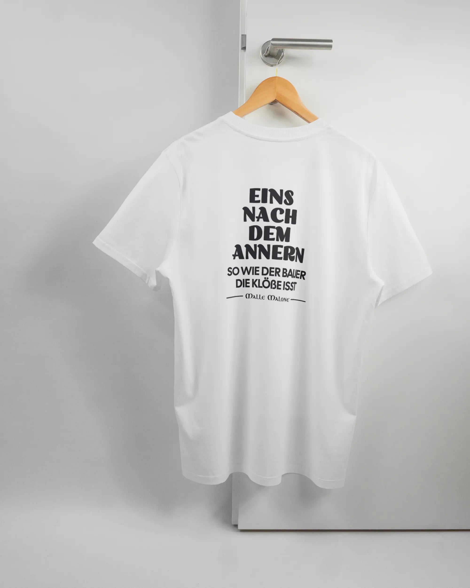 Rückseite des Organic Unisex T-Shirt Casual von Maondo mit dem Design Eins nach dem Annern in der Farbe White und in der Größe L auf einem Bügel an der Türklinke aufgehängt
