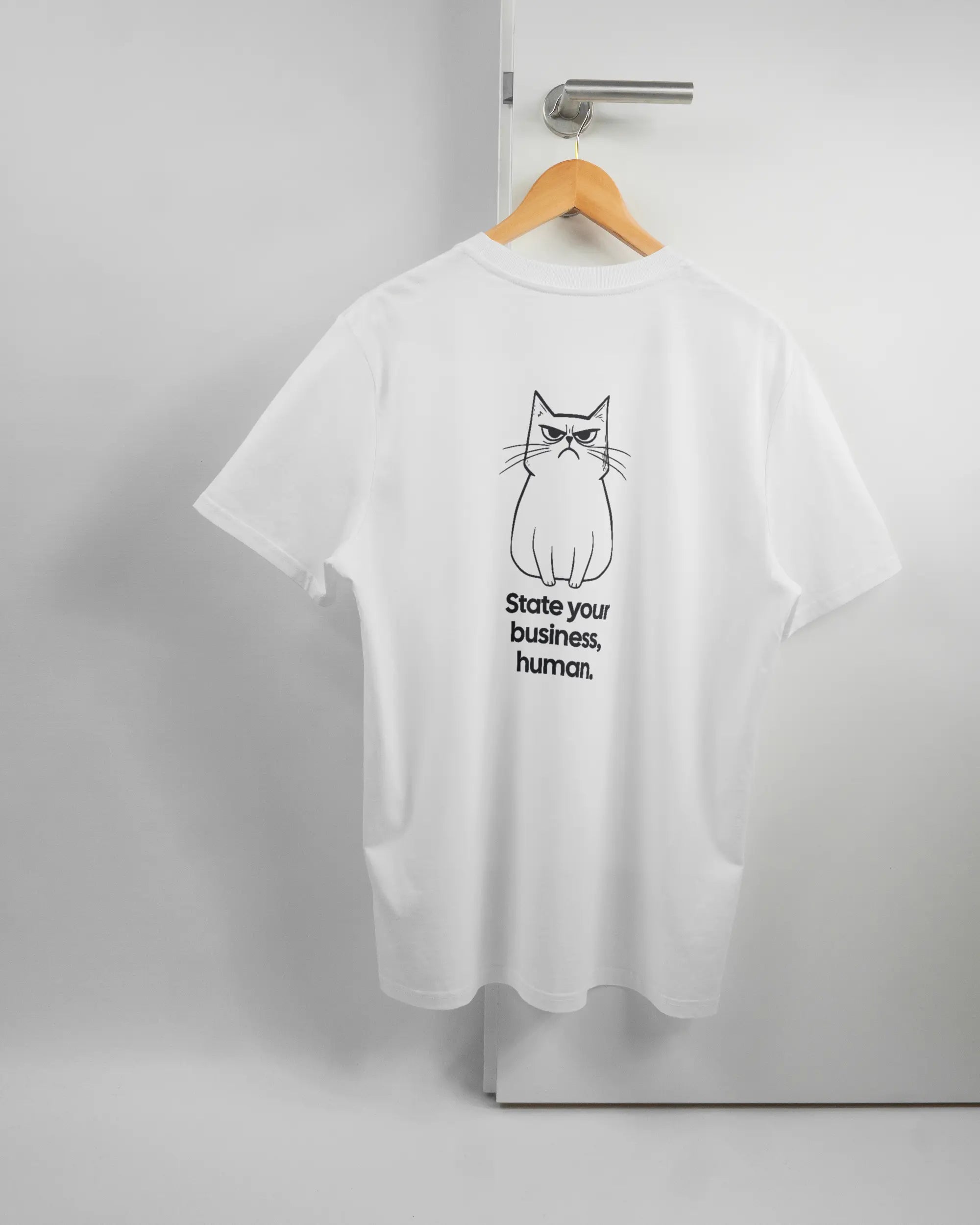 Rückseite des Organic Unisex T-Shirt Casual von Maondo mit dem Design Grumpy Purr in der Farbe White und in der Größe L auf einem Bügel an der Türklinke aufgehängt