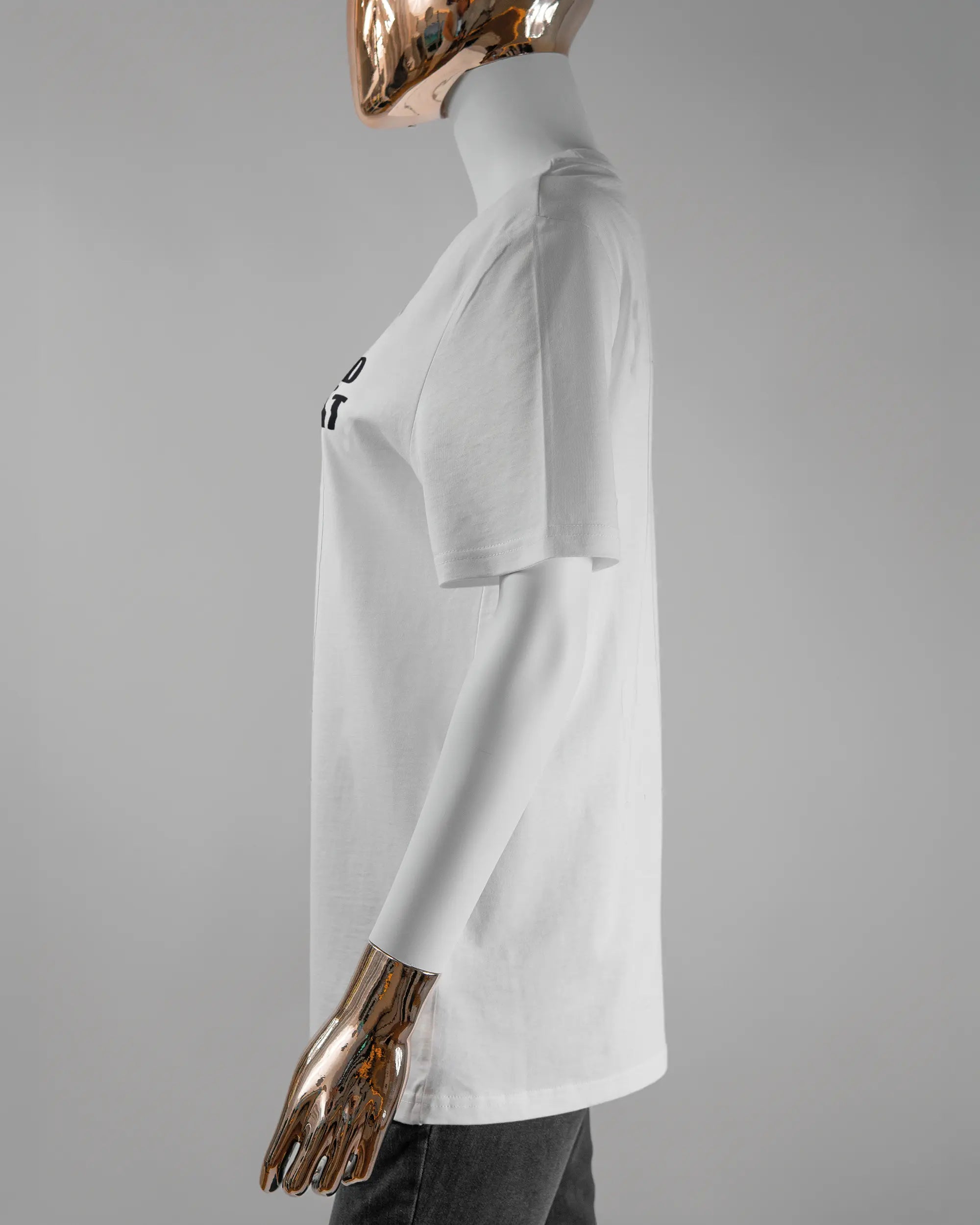 Seitenansicht des Organic Unisex T-Shirt Casual von Maondo mit dem Design Keine Eile vorne in der Farbe White und in der Größe S getragen von einer femininen Puppe