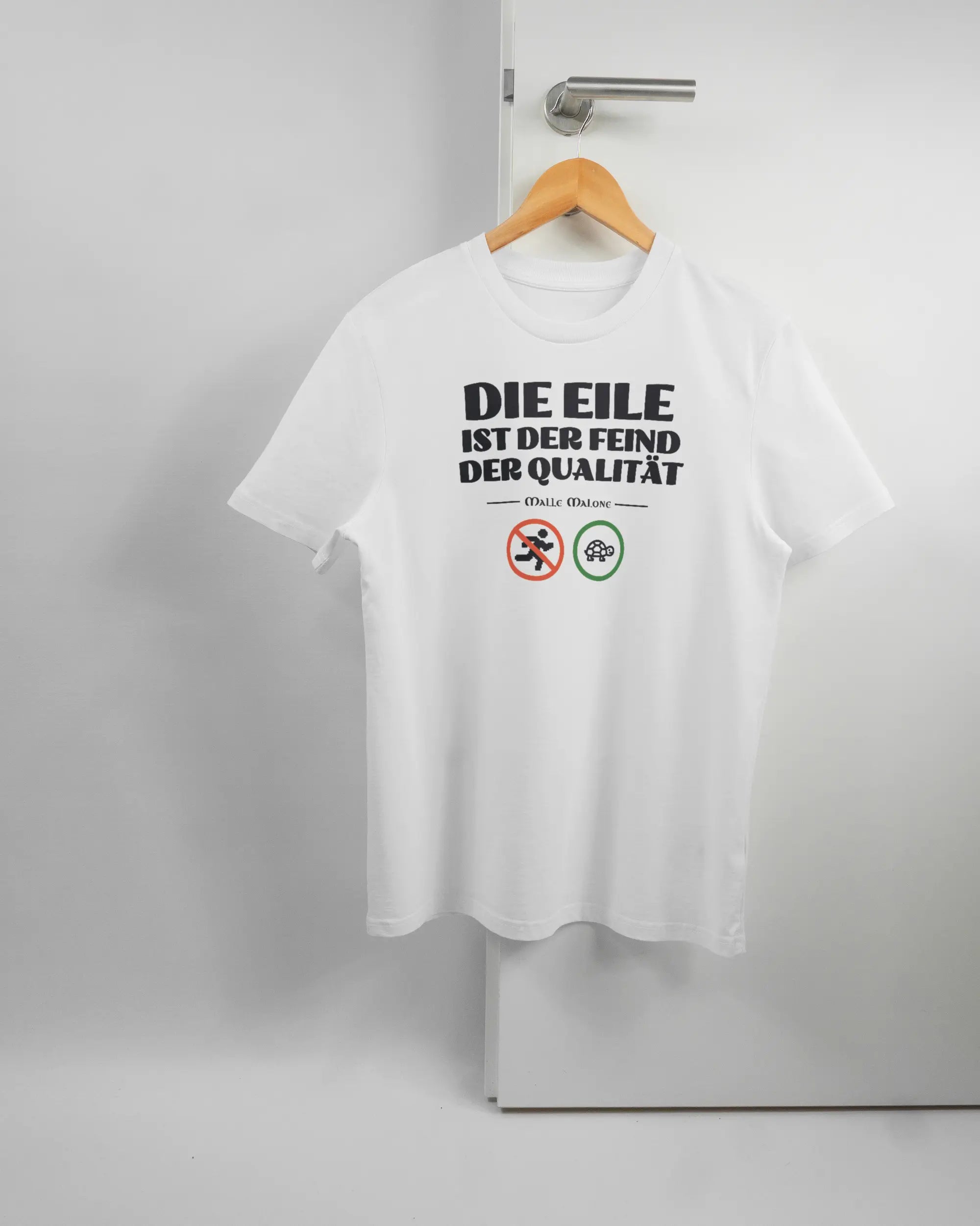 Vorderseite des Organic Unisex T-Shirt Casual von Maondo mit dem Design Keine Eile in der Farbe White und in der Größe S auf einem Bügel an der Türklinke aufgehängt
