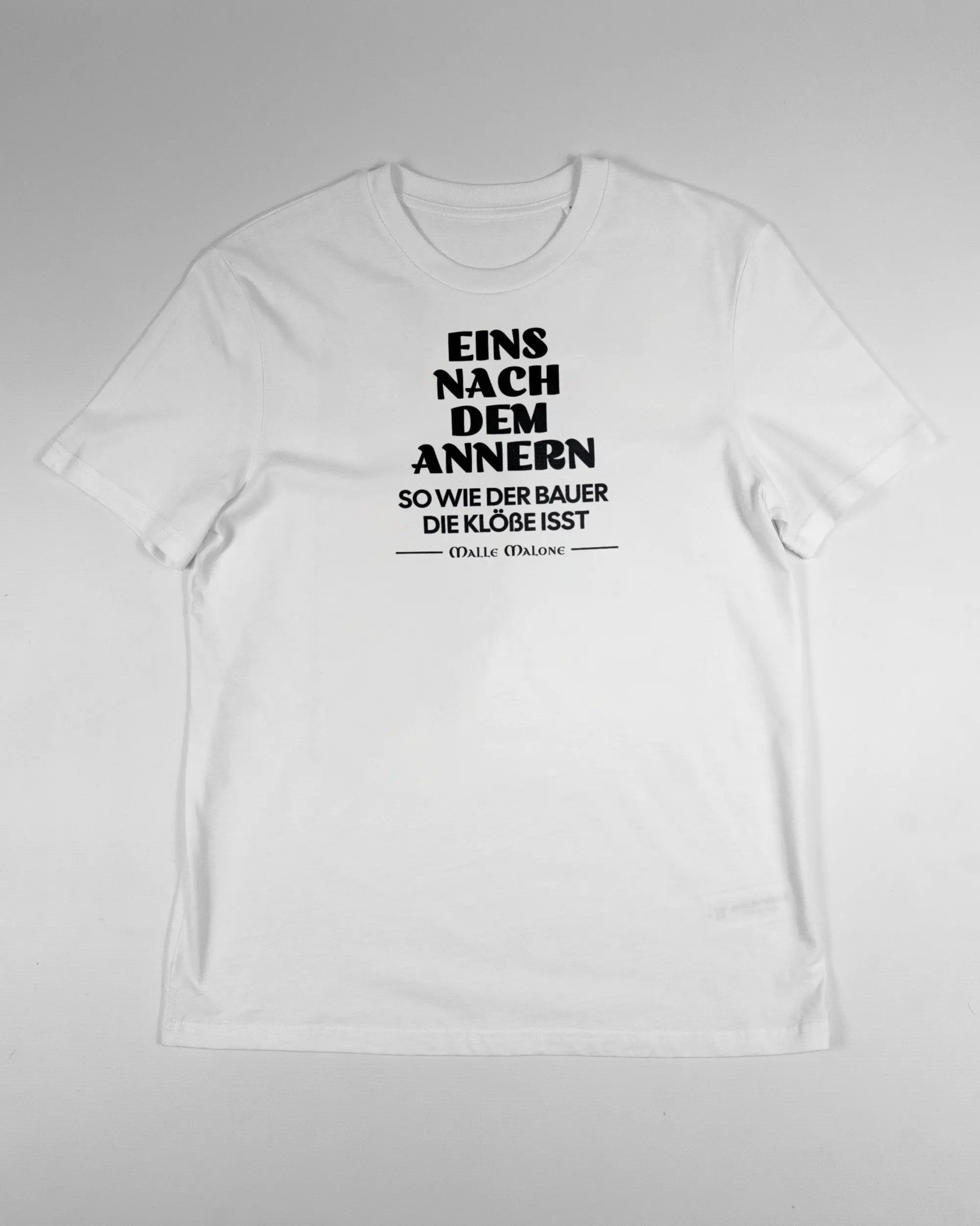 Vorderseite des Organic Unisex T-Shirt Casual von Maondo mit dem Design Eins nach dem Annern in der Farbe White und in der Größe S flach auf den Boden gelegt