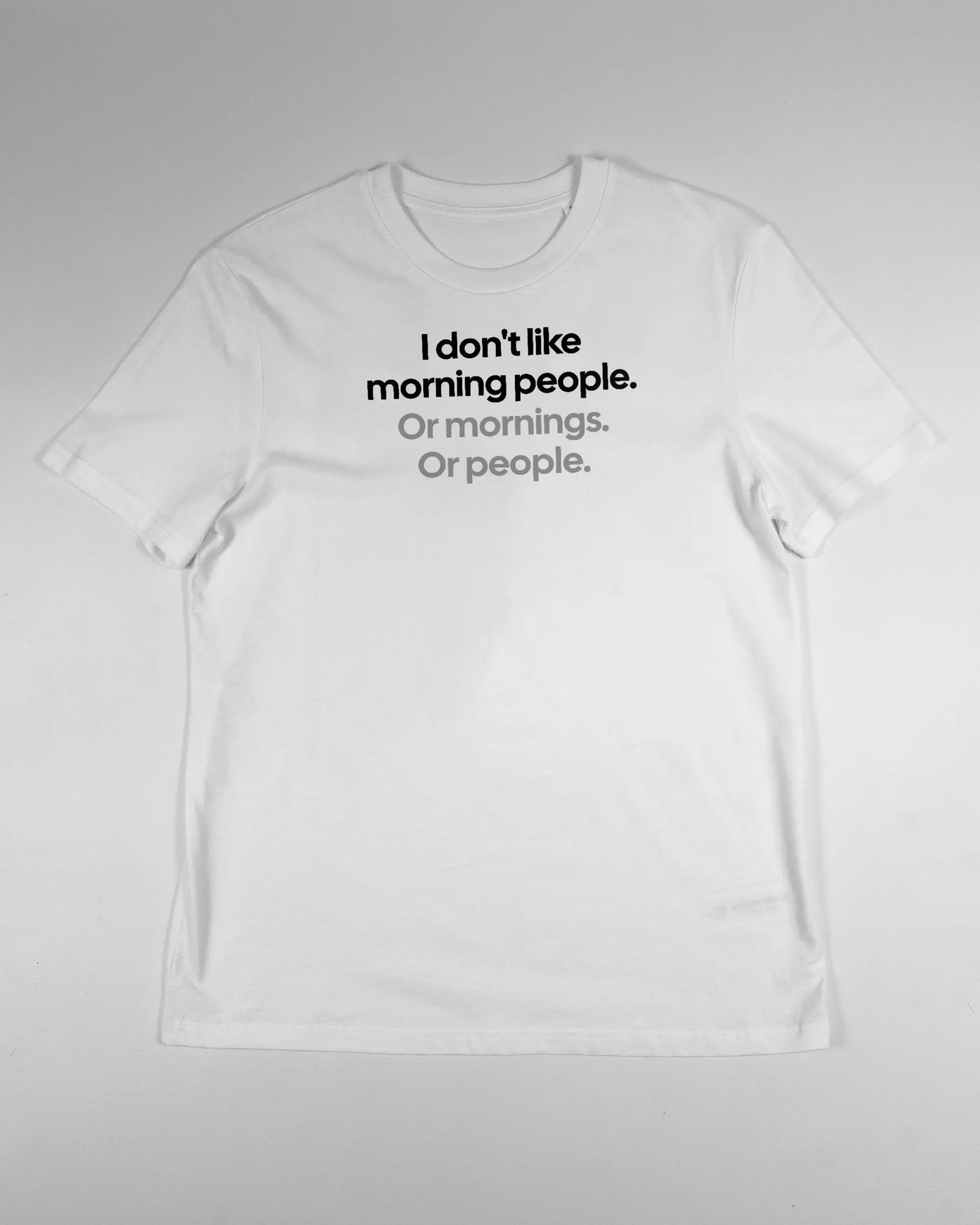 Vorderseite des Organic Unisex T-Shirt Casual von Maondo mit dem Design Morning Person in der Farbe White und in der Größe S flach auf den Boden gelegt