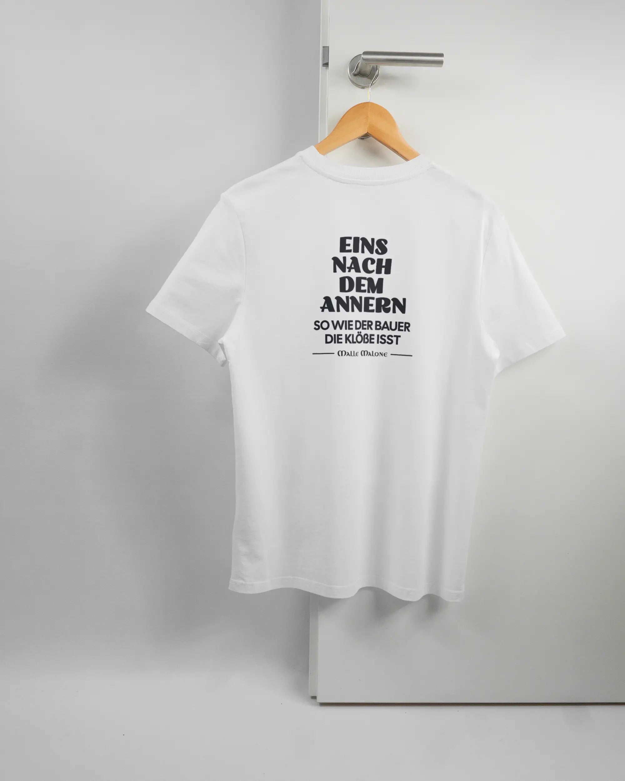 Rückseite des Organic Unisex T-Shirt Casual von Maondo mit dem Design Eins nach dem Annern in der Farbe White und in der Größe S auf einem Bügel an der Türklinke aufgehängt