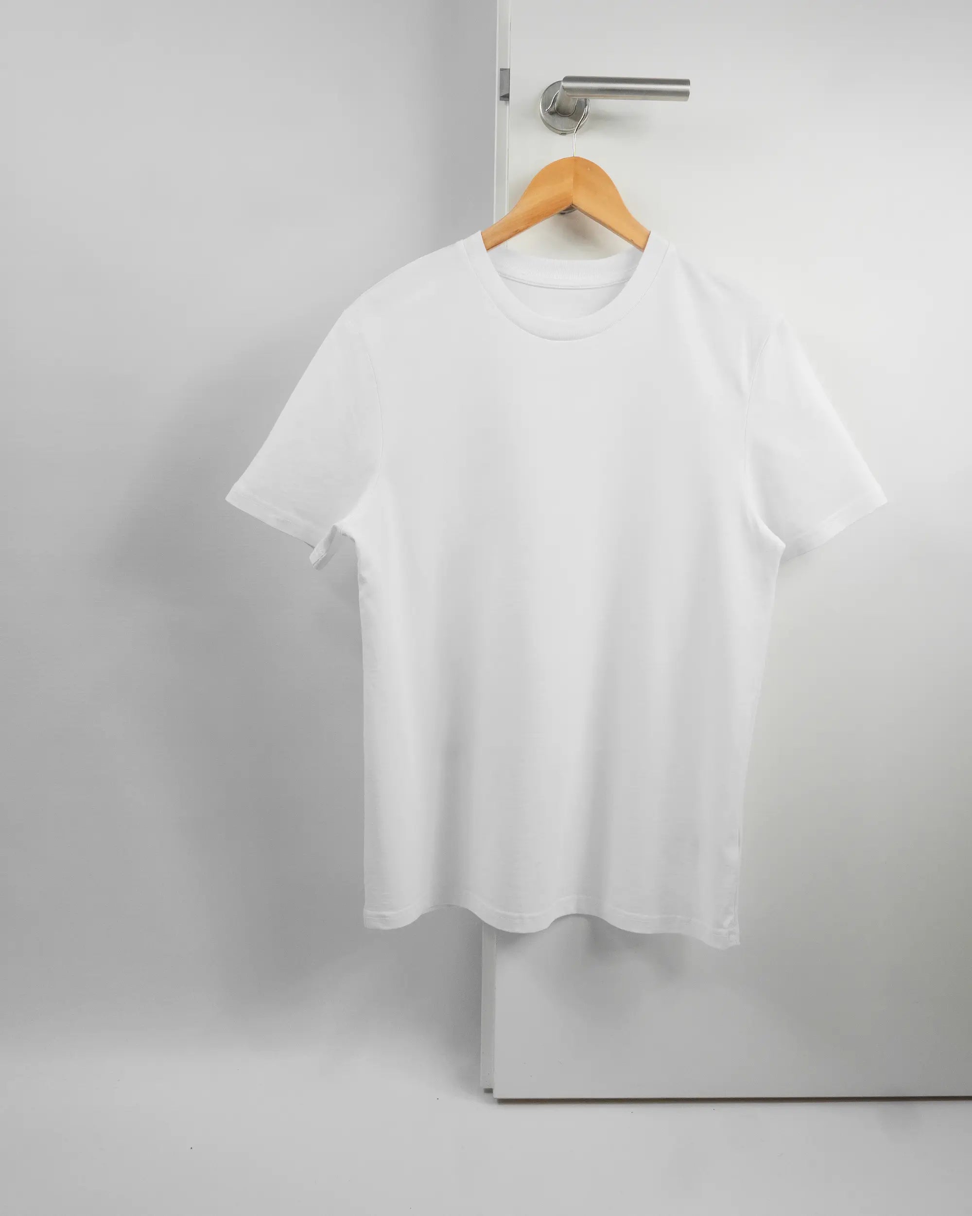 Vorderseite des Organic Unisex T-Shirt Casual von Maondo ohne Motiv in der Farbe White und in der Größe S auf einem Bügel an der Türklinke aufgehängt