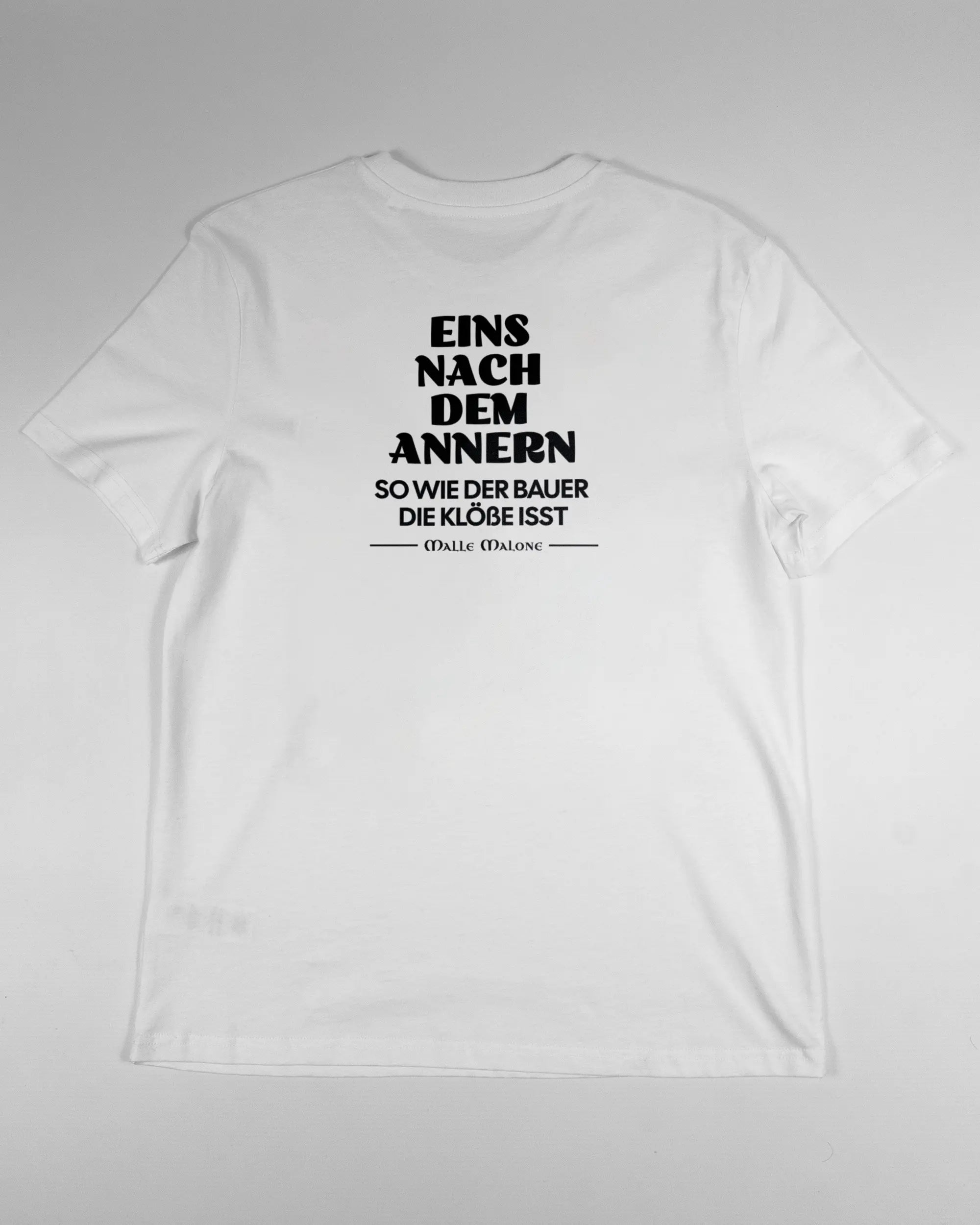 Rückseite des Organic Unisex T-Shirt Casual von Maondo mit dem Design Eins nach dem Annern in der Farbe White und in der Größe S flach auf den Boden gelegt