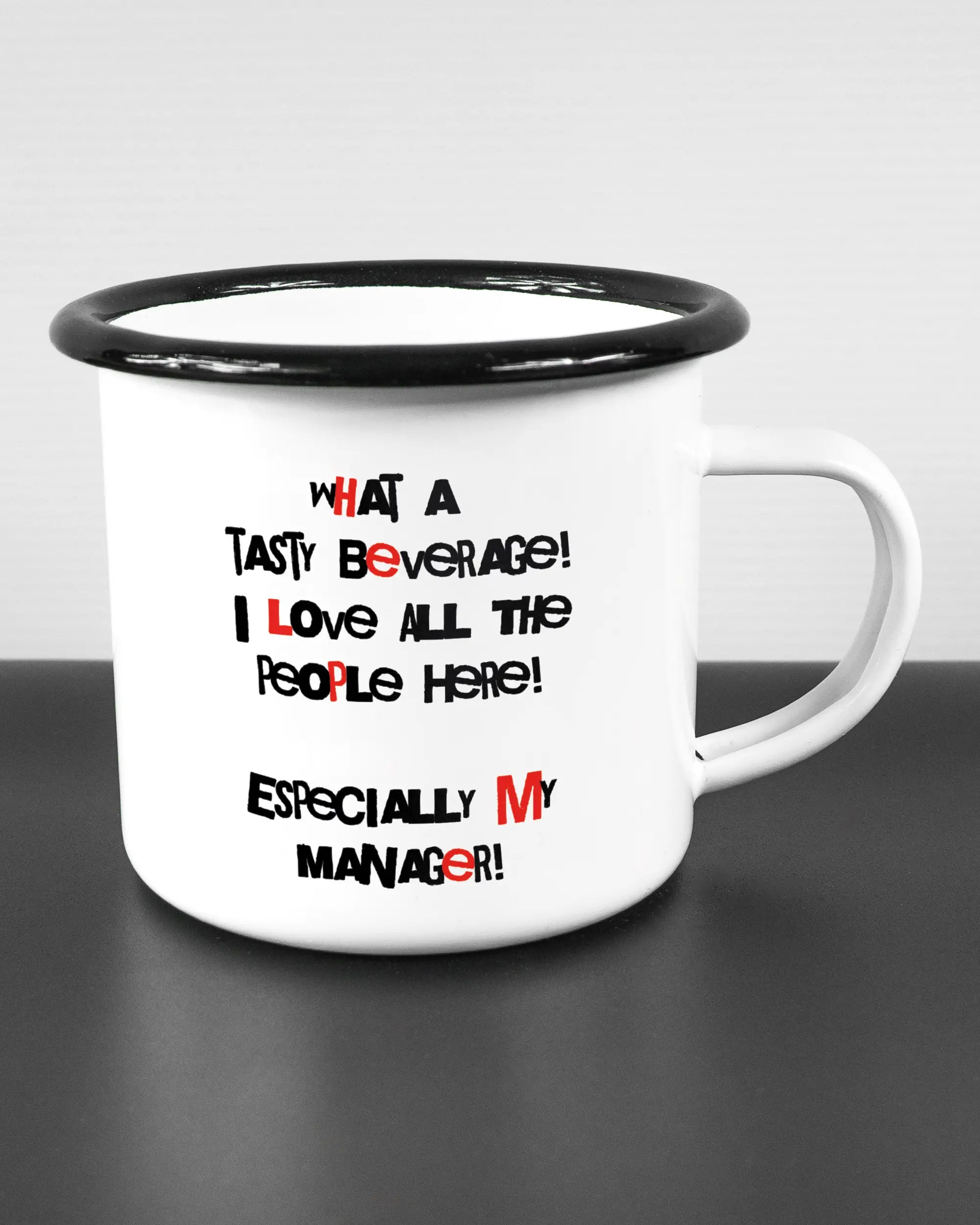 Alternativbild, das die rechte Seite der beidseitig bedruckten Emailletasse von Maondo mit dem Design Help me in der Farbe White-Black auf einem Holztisch zeigt