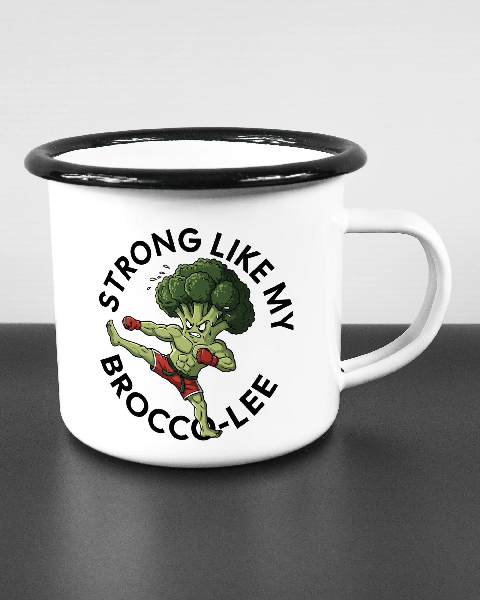 Alternativbild, das die rechte Seite der beidseitig bedruckten Emailletasse von Maondo mit dem Design Brocco-Lee in der Farbe White-Black auf einem Holztisch zeigt