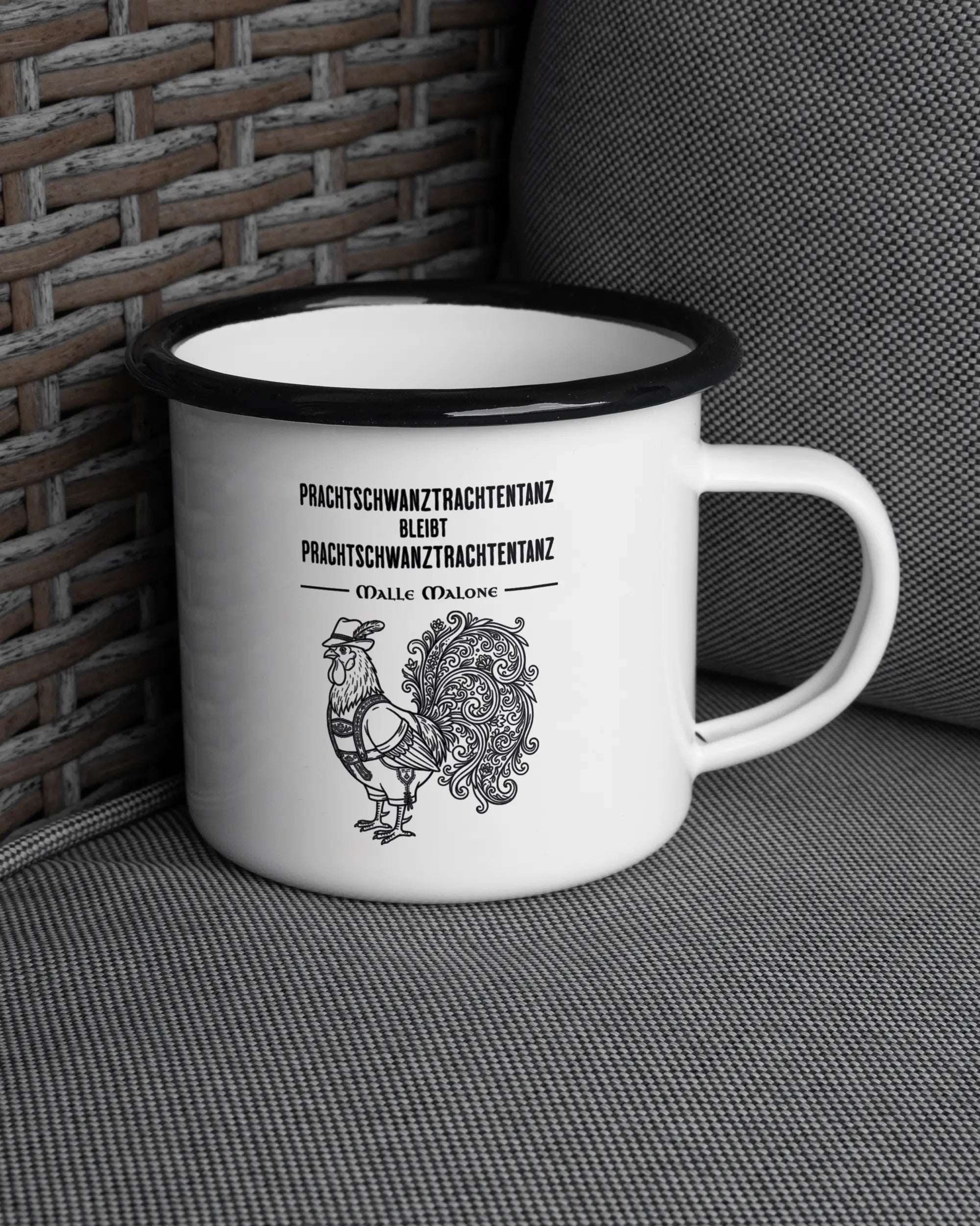 Ansicht der rechten Seite der beidseitig bedruckten Emailletasse von Maondo auf einem Balkonmöbel bzw. Campingstuhl mit dem Design Trachtentanz in der Farbe White-Black