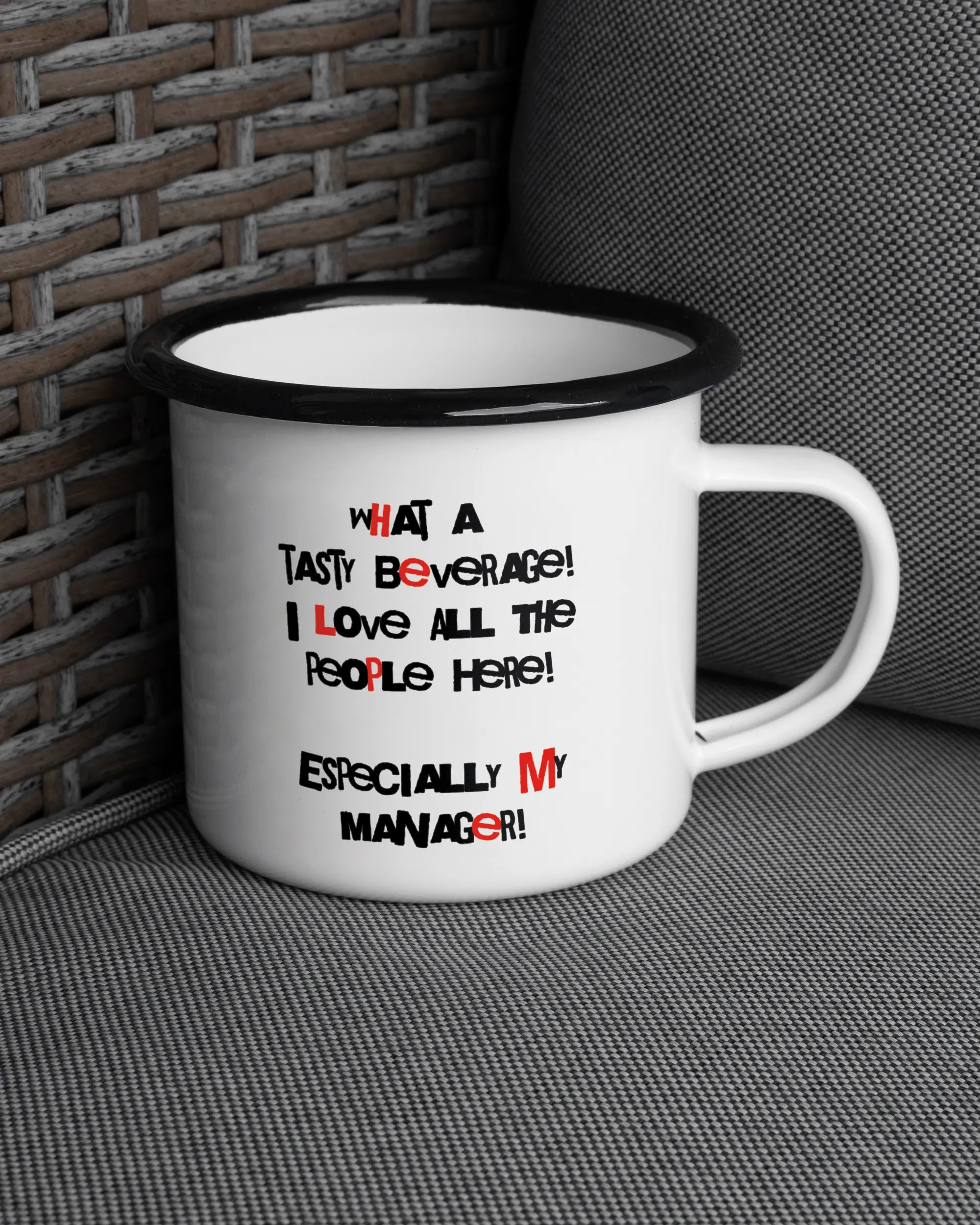 Ansicht der rechten Seite der beidseitig bedruckten Emailletasse von Maondo auf einem Balkonmöbel bzw. Campingstuhl mit dem Design Help me in der Farbe White-Black