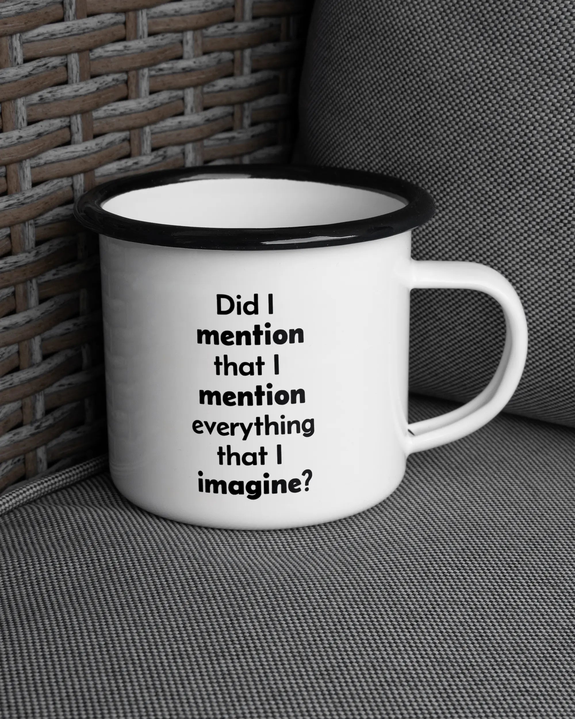 Ansicht der rechten Seite der beidseitig bedruckten Emailletasse von Maondo auf einem Balkonmöbel bzw. Campingstuhl mit dem Design Did I mention in der Farbe White-Black