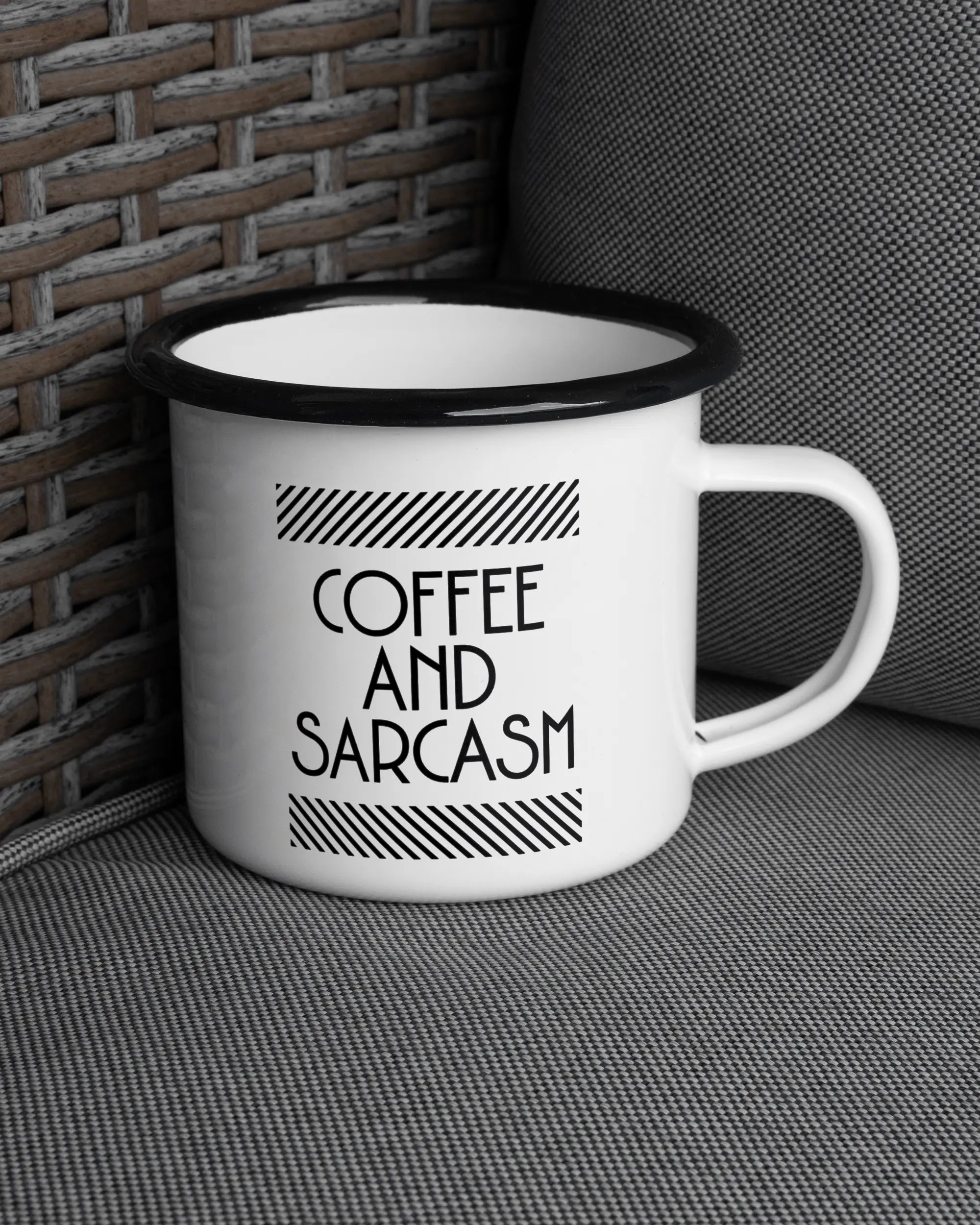 Ansicht der rechten Seite der beidseitig bedruckten Emailletasse von Maondo auf einem Balkonmöbel bzw. Campingstuhl mit dem Design Sarcastic Cup in der Farbe White-Black