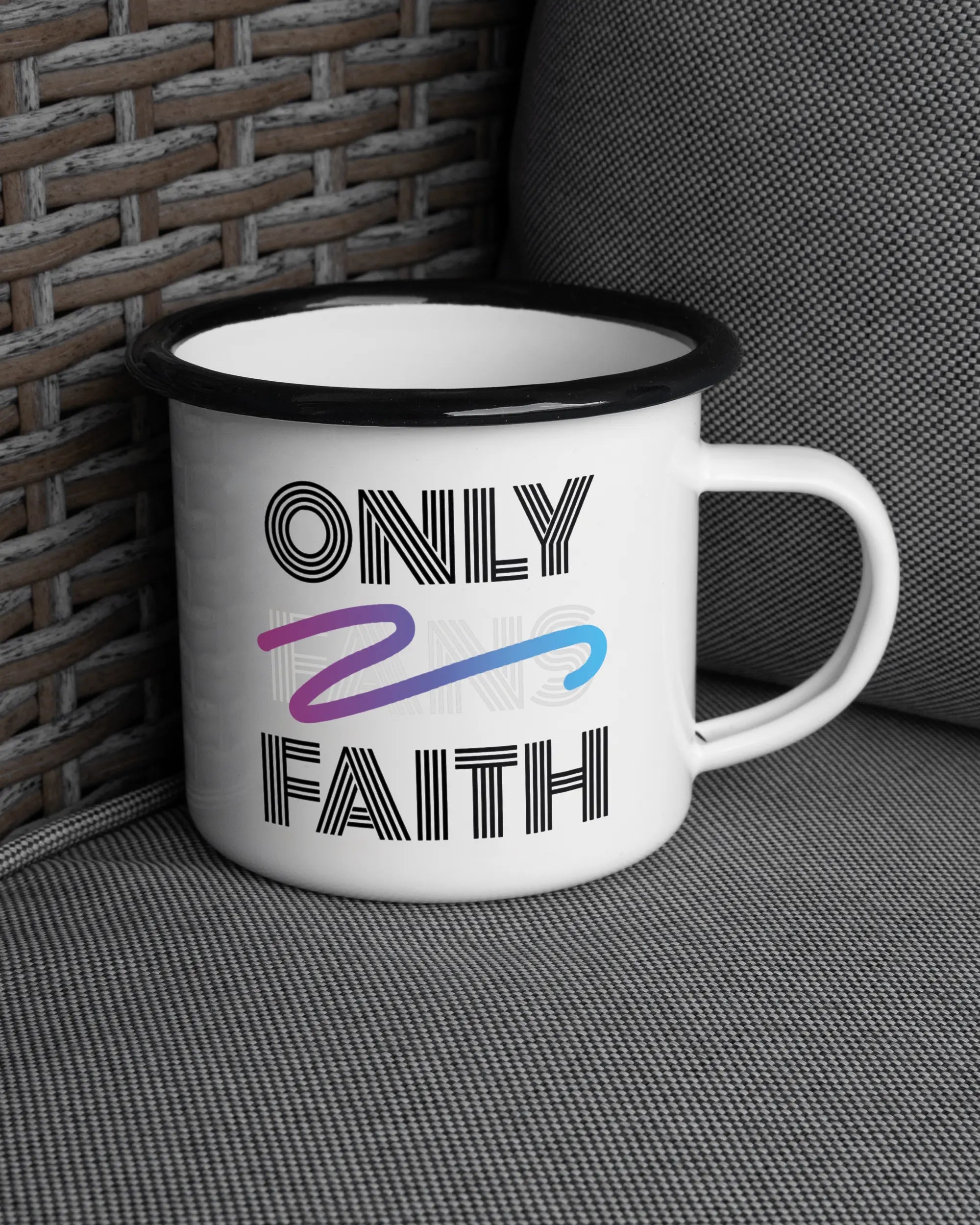 Ansicht der rechten Seite der beidseitig bedruckten Emailletasse von Maondo auf einem Balkonmöbel bzw. Campingstuhl mit dem Design Only Faith in der Farbe White-Black