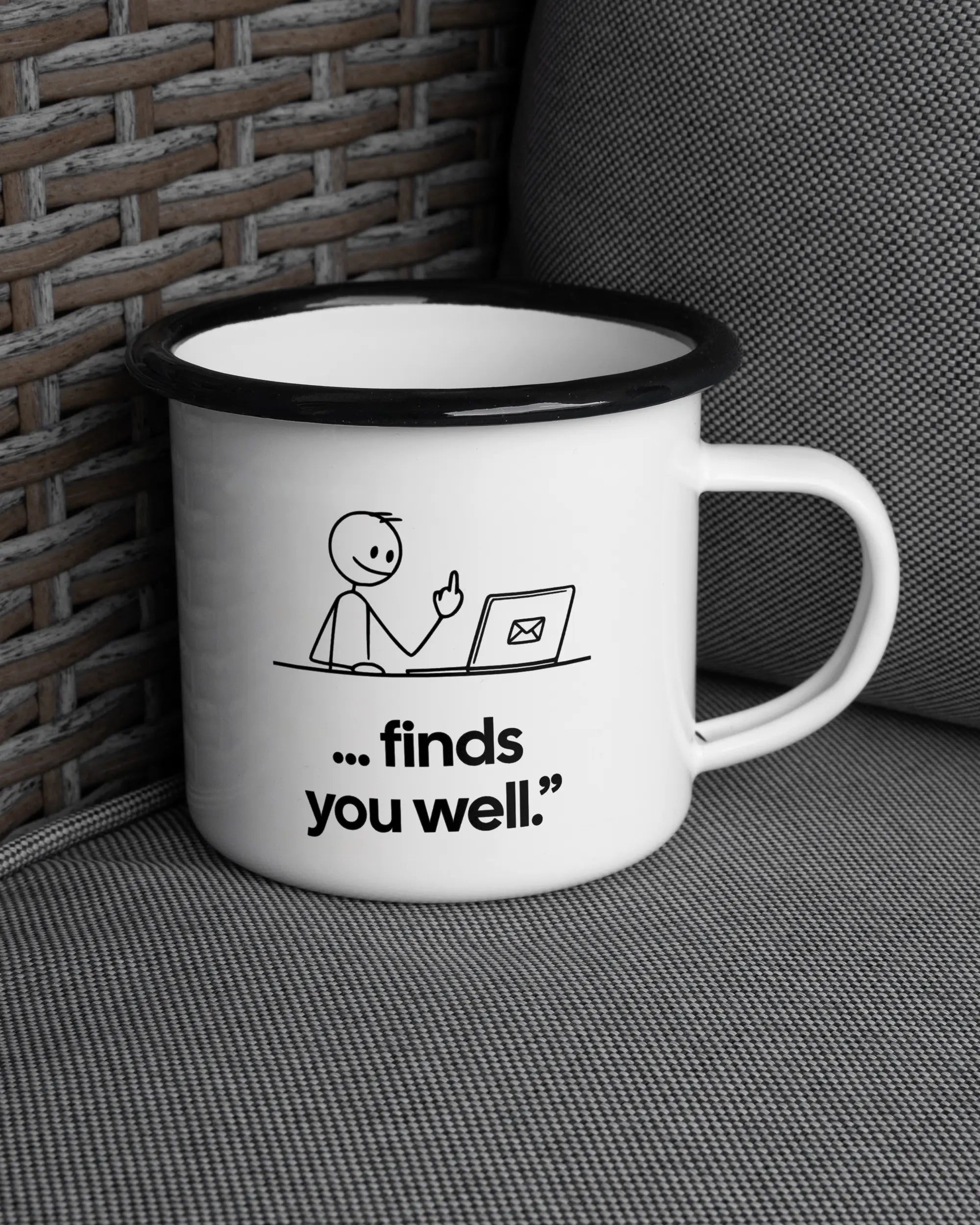 Ansicht der rechten Seite der beidseitig bedruckten Emailletasse von Maondo auf einem Balkonmöbel bzw. Campingstuhl mit dem Design Found me not well in der Farbe White-Black