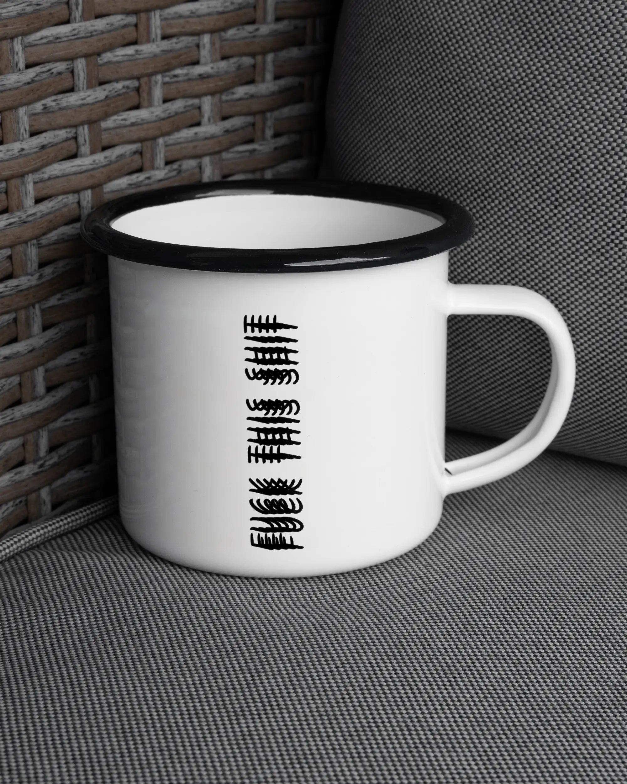 Ansicht der rechten Seite der beidseitig bedruckten Emailletasse von Maondo auf einem Balkonmöbel bzw. Campingstuhl mit dem Design Hidden Message in der Farbe White-Black