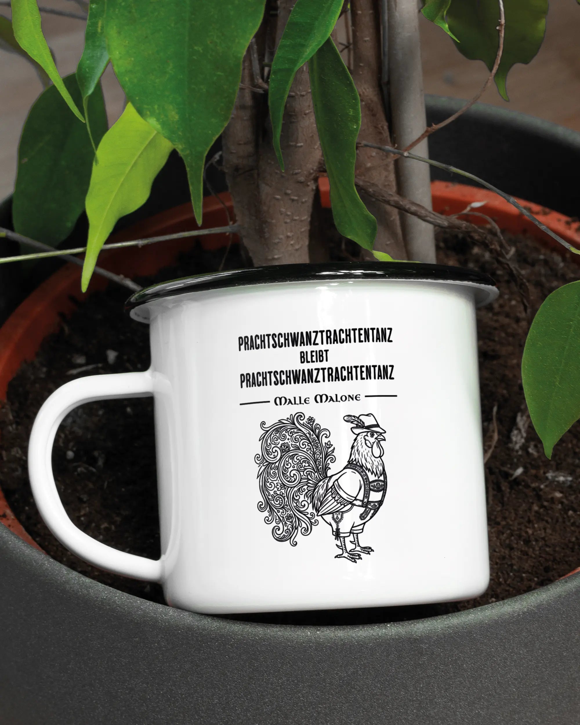 Aufnahme der linken Seite der beidseitig bedruckten Emailletasse von Maondo mit dem Design Trachtentanz in der Farbe White-Black in einem Blumentopf