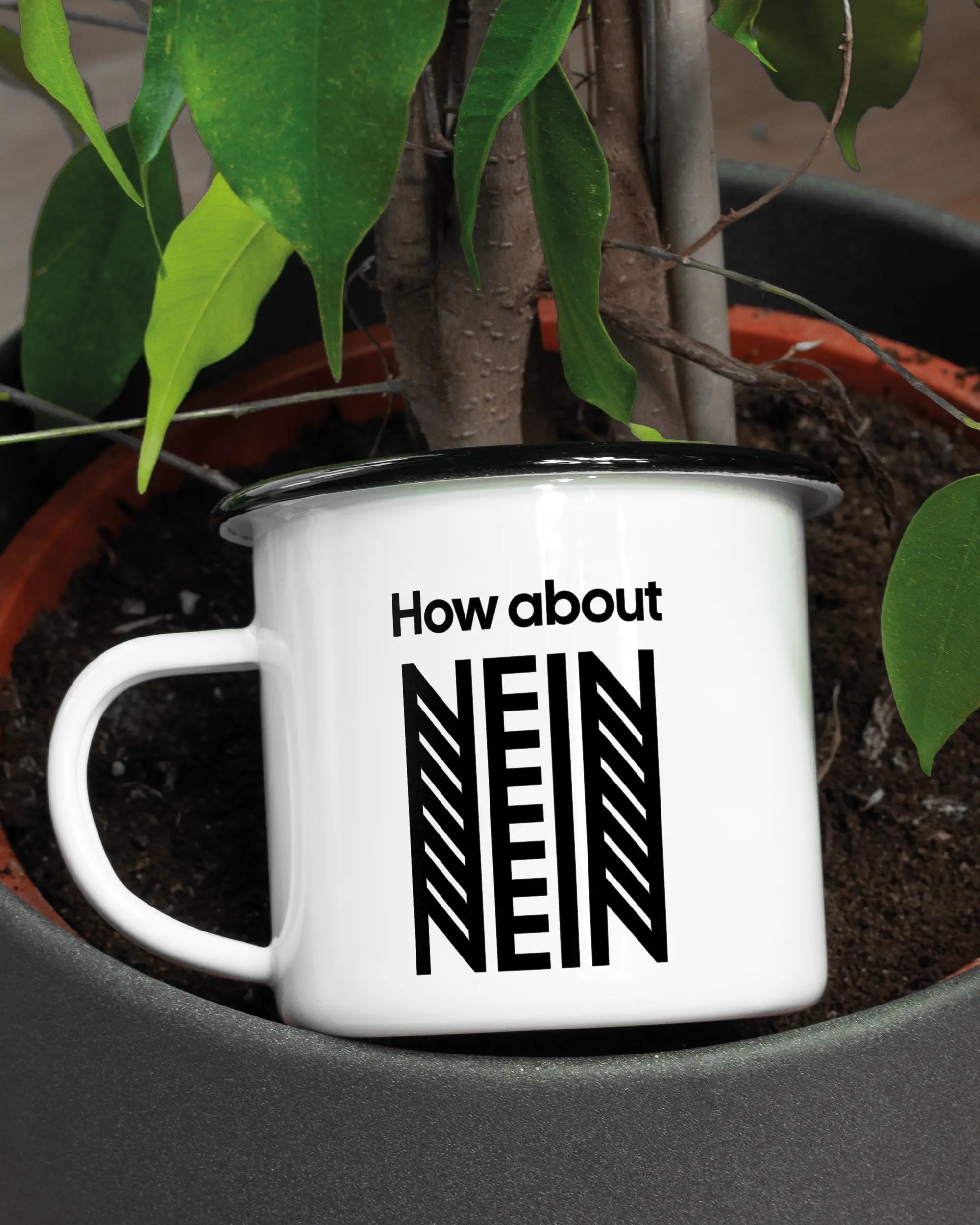 Aufnahme der linken Seite der beidseitig bedruckten Emailletasse von Maondo mit dem Design How about nein in der Farbe White-Black in einem Blumentopf