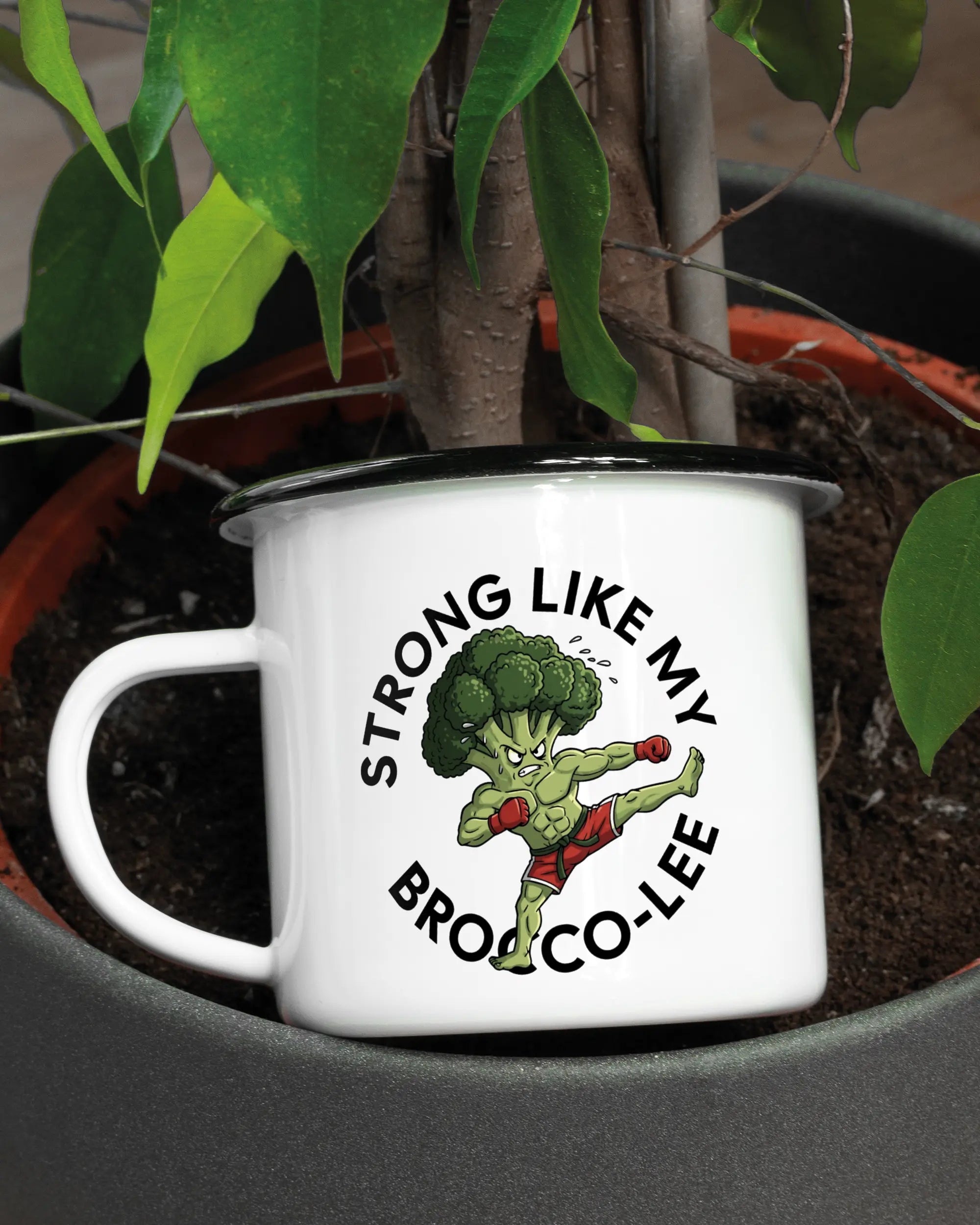 Aufnahme der linken Seite der beidseitig bedruckten Emailletasse von Maondo mit dem Design Brocco-Lee in der Farbe White-Black in einem Blumentopf