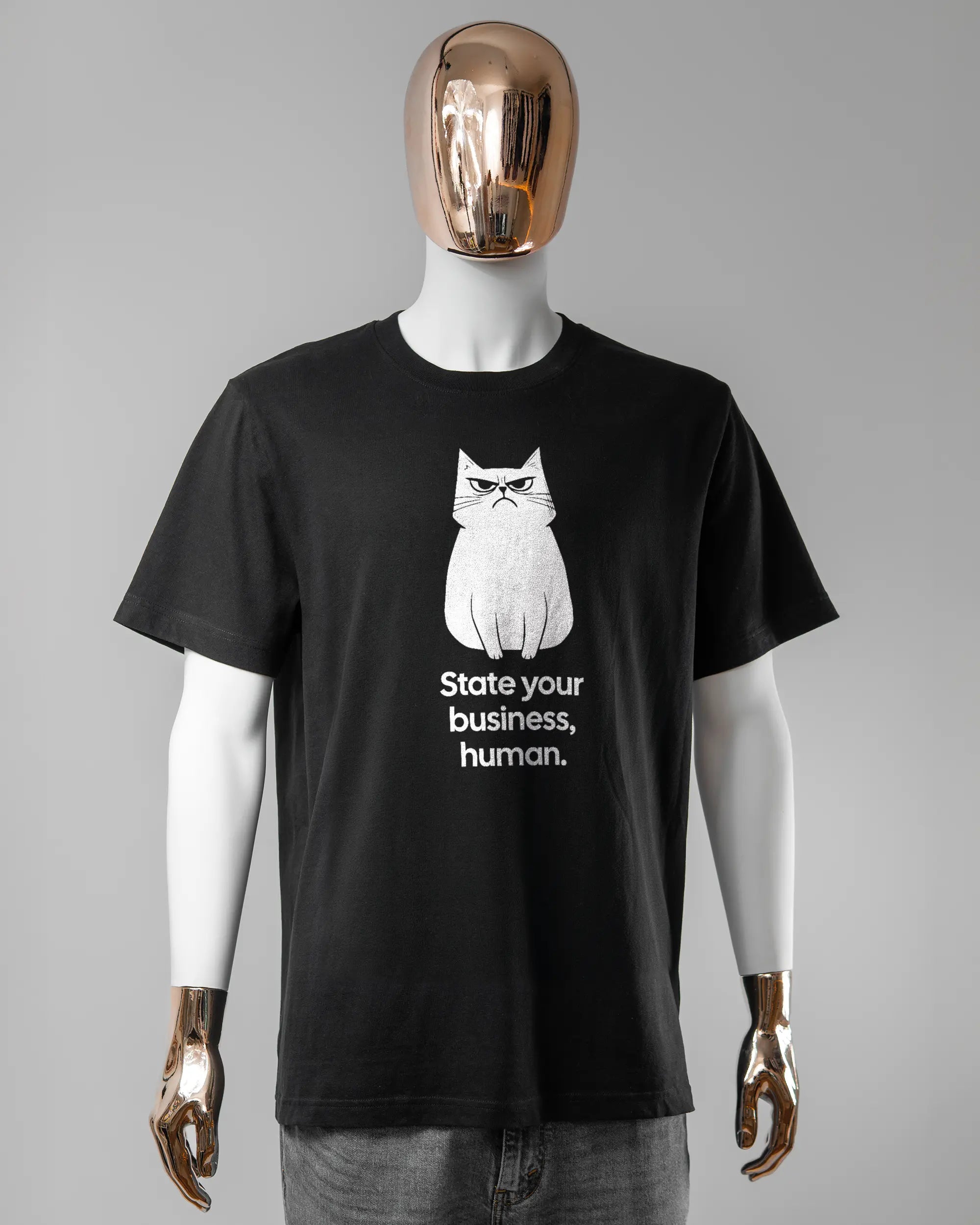 Vorderseite des Organic Unisex T-Shirt Relaxed von Maondo mit dem Design Grumpy Purr in der Farbe Black und in der Größe L getragen von einer maskulinen Puppe
