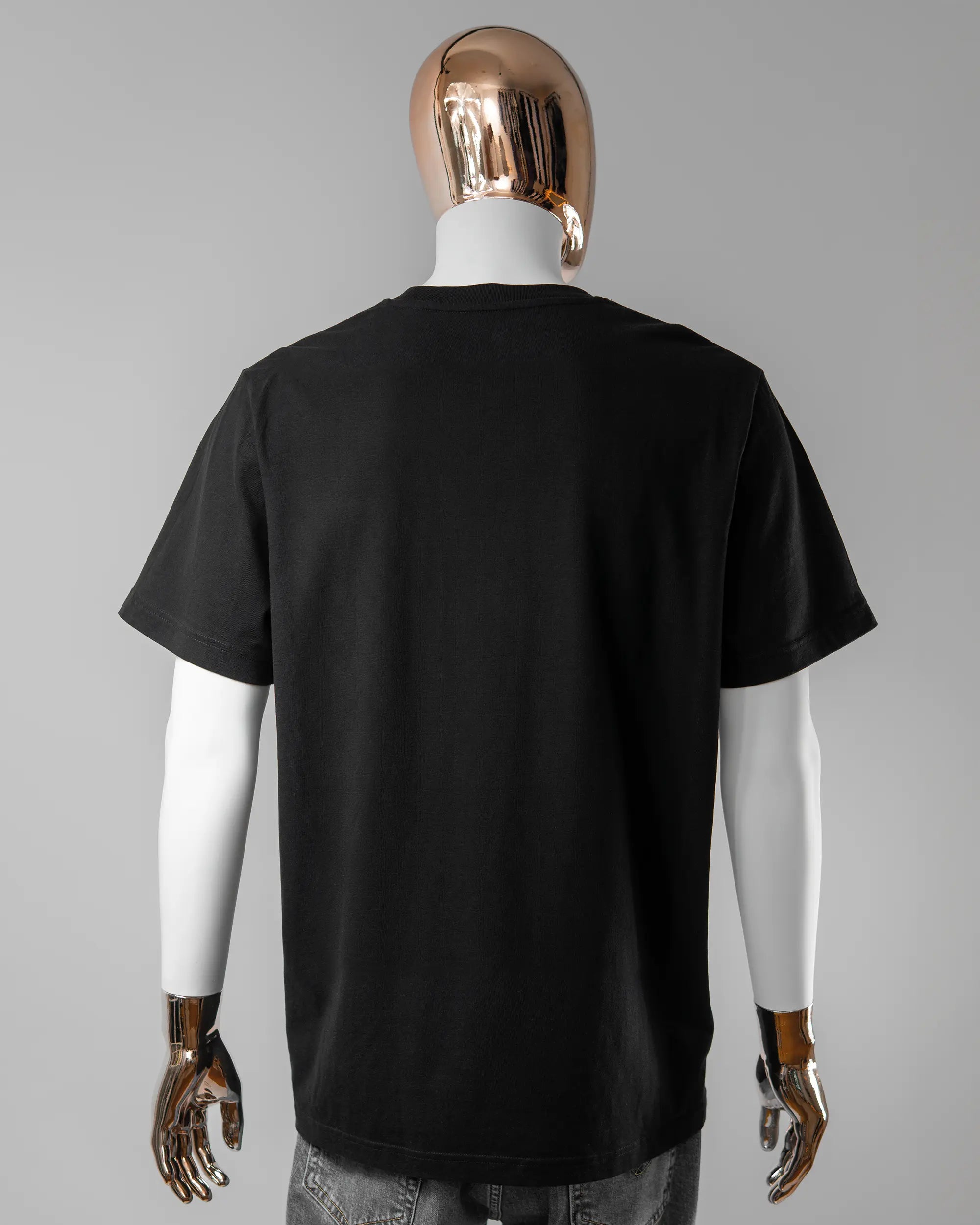 Rückseite des Organic Unisex T-Shirt Relaxed von Maondo ohne Motiv in der Farbe Black und in der Größe L getragen von einer maskulinen Puppe