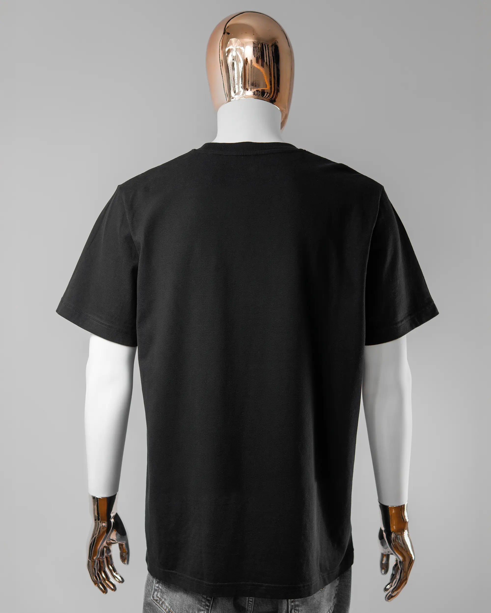 Rückseite des Organic Unisex T-Shirt Relaxed von Maondo ohne Motiv in der Farbe Black und in der Größe L getragen von einer maskulinen Puppe