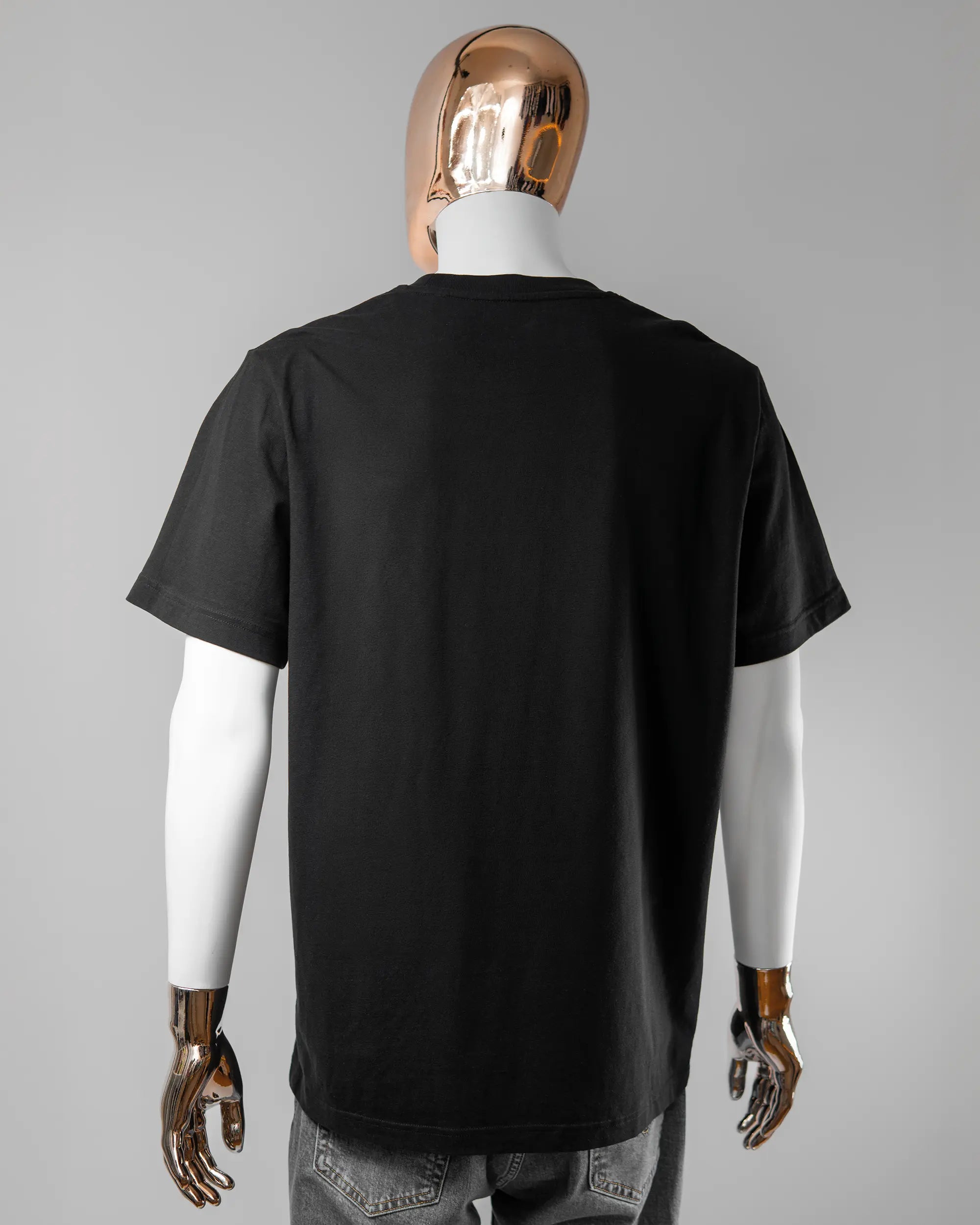 Rückseite des Organic Unisex T-Shirt Relaxed von Maondo ohne Motiv in der Farbe Black und in der Größe L getragen von einer maskulinen Puppe