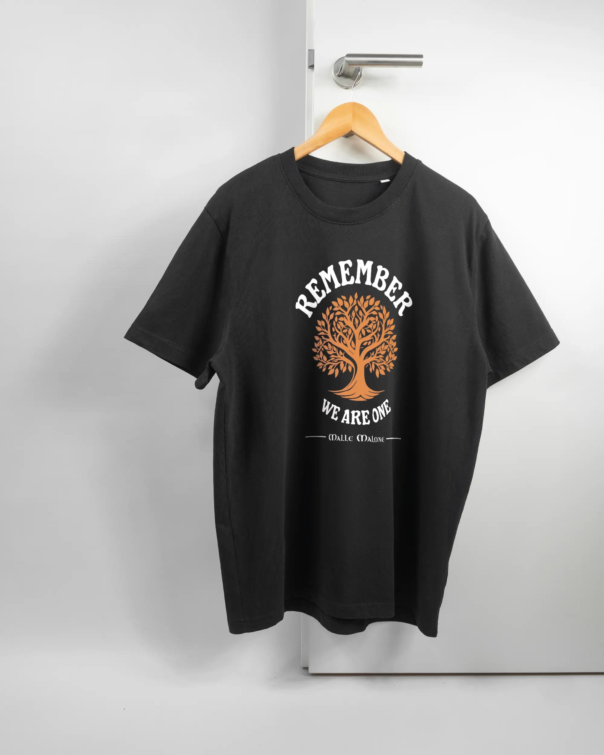 Vorderseite des Organic Unisex T-Shirt Relaxed von Maondo mit dem Design We are one in der Farbe Black und in der Größe L auf einem Bügel an der Türklinke aufgehängt