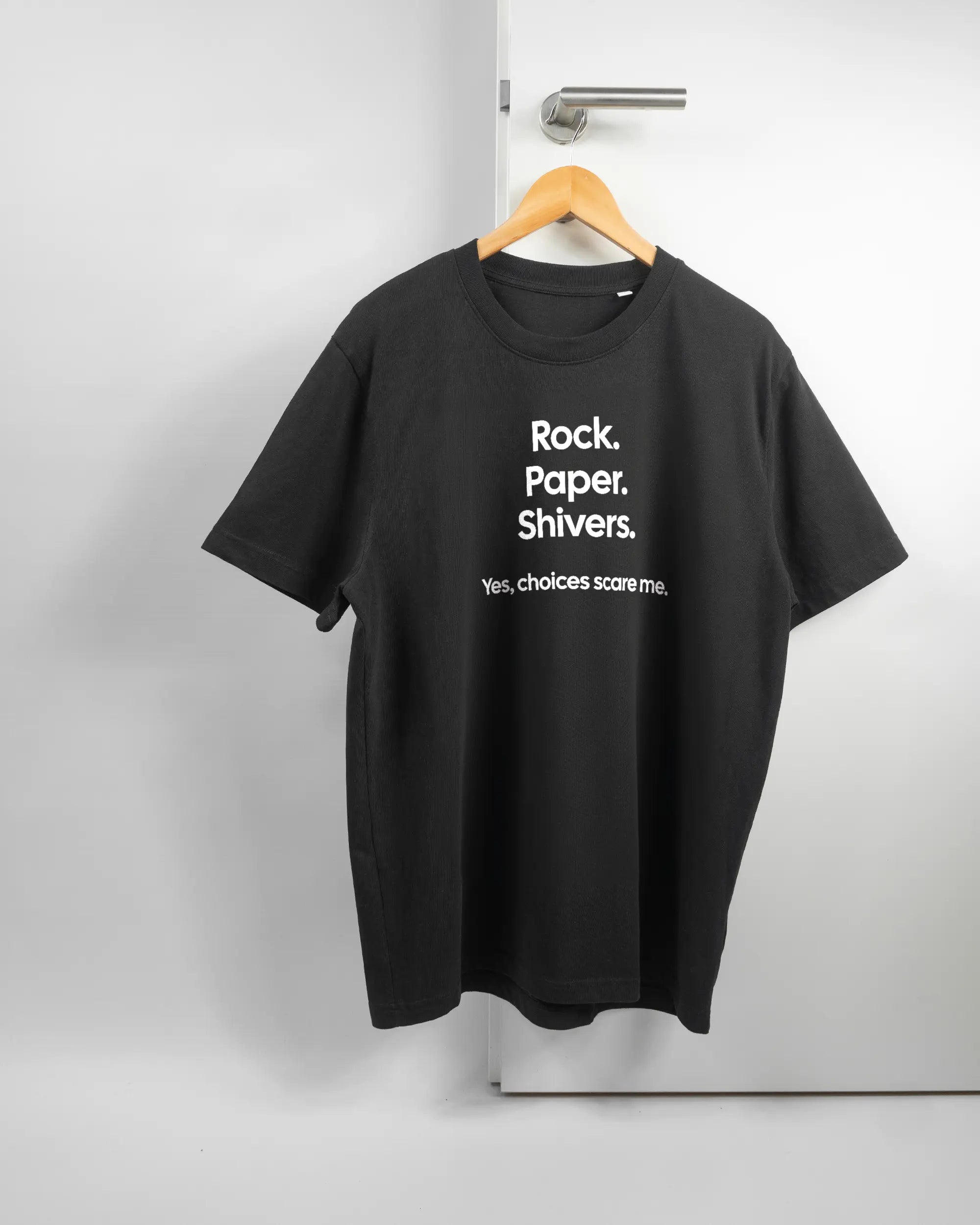 Vorderseite des Organic Unisex T-Shirt Relaxed von Maondo mit dem Design Rock Paper Shivers in der Farbe Black und in der Größe L auf einem Bügel an der Türklinke aufgehängt