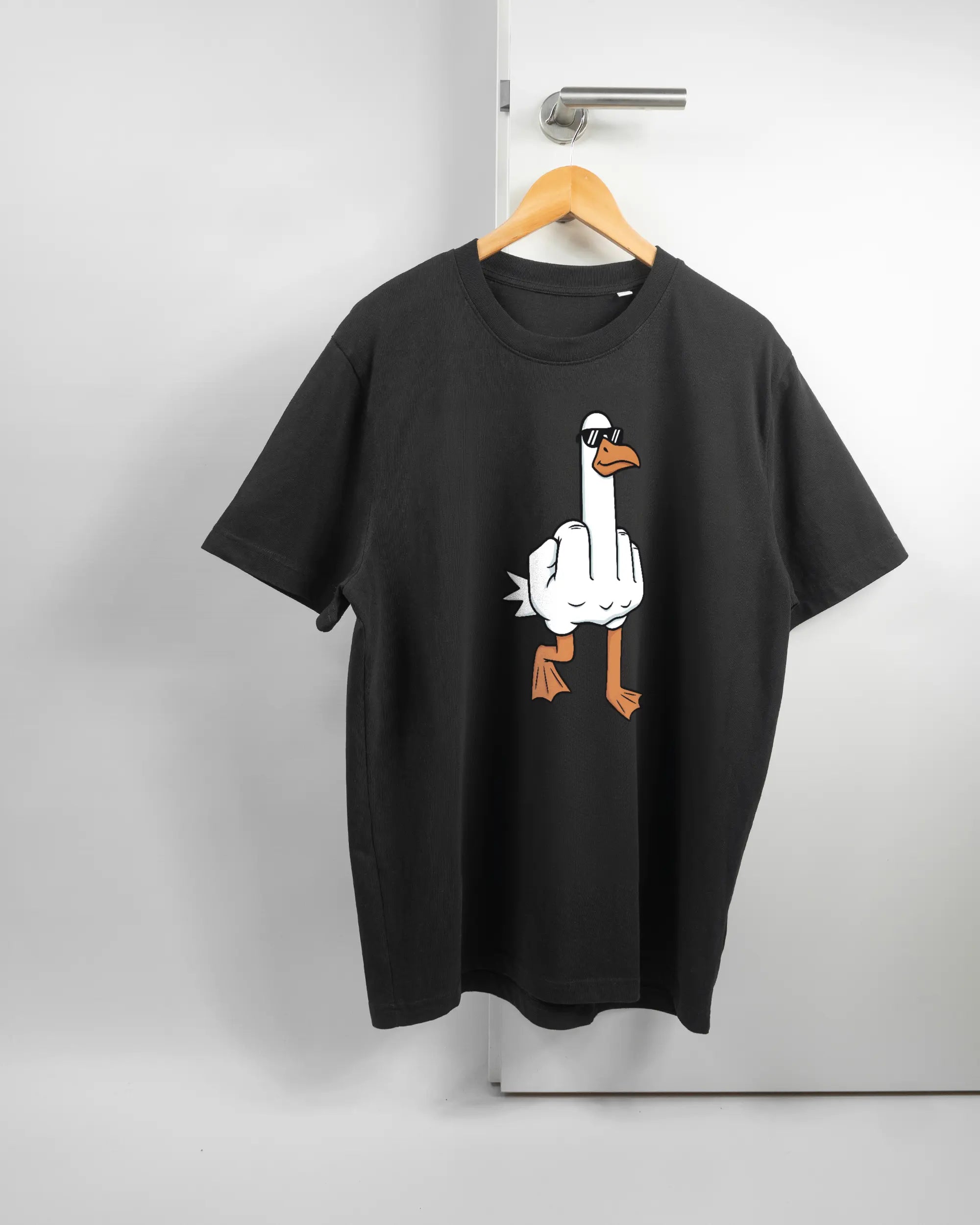 Vorderseite des Organic Unisex T-Shirt Relaxed von Maondo mit dem Design I give a duck in der Farbe Black und in der Größe L auf einem Bügel an der Türklinke aufgehängt
