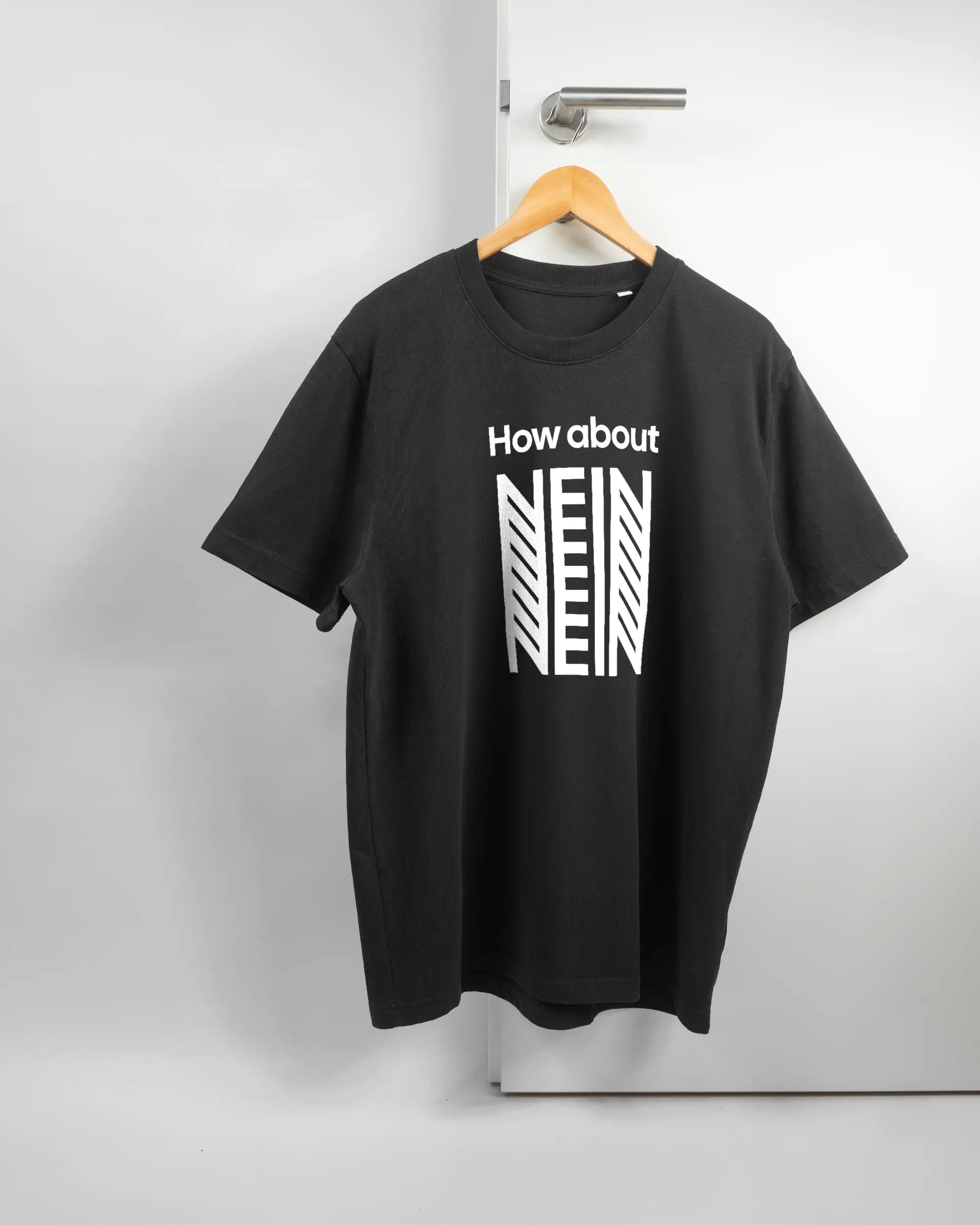 Vorderseite des Organic Unisex T-Shirt Relaxed von Maondo mit dem Design How about nein in der Farbe Black und in der Größe L auf einem Bügel an der Türklinke aufgehängt