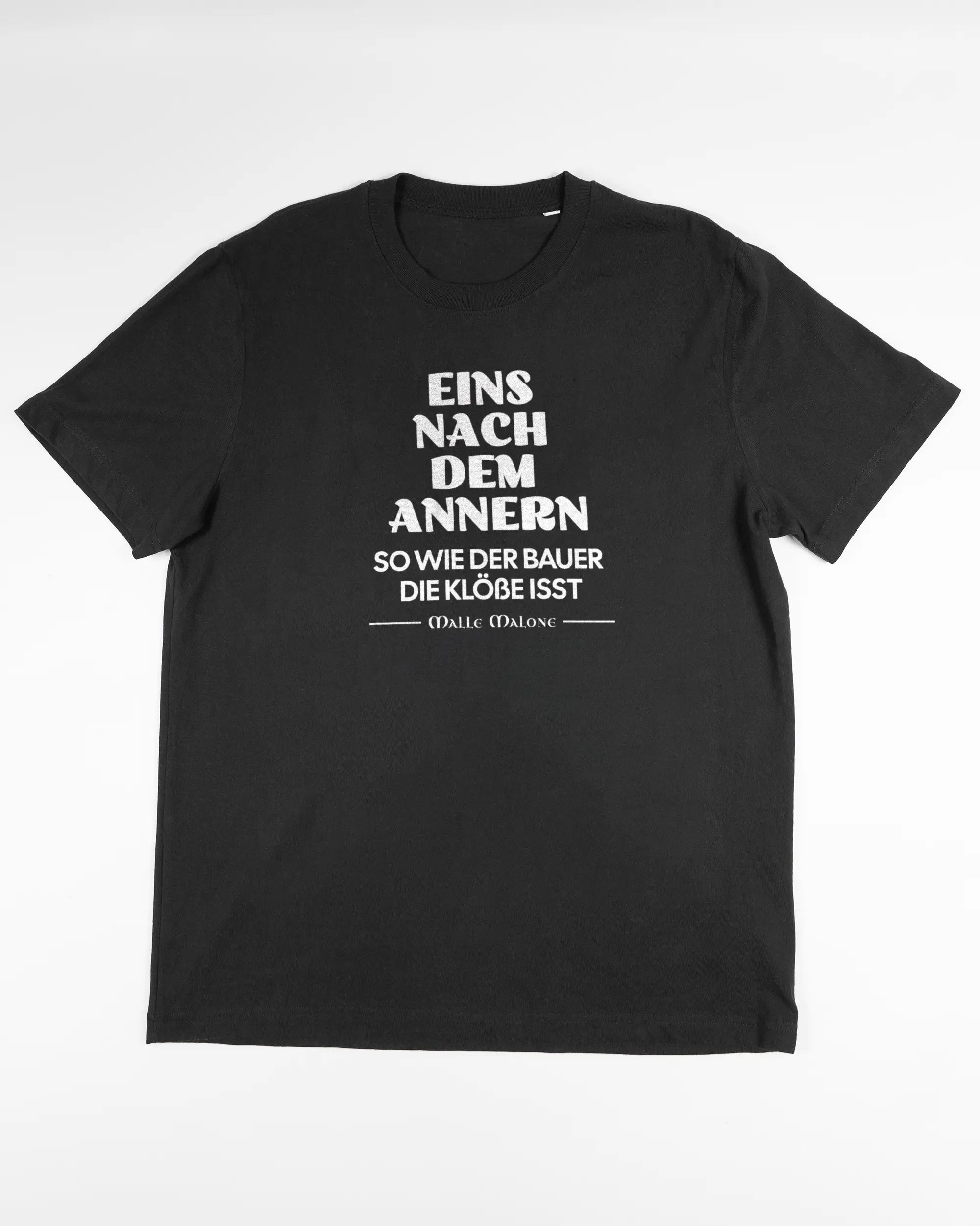 Vorderseite des Organic Unisex T-Shirt Relaxed von Maondo mit dem Design Eins nach dem Annern in der Farbe Black und in der Größe L flach auf den Boden gelegt
