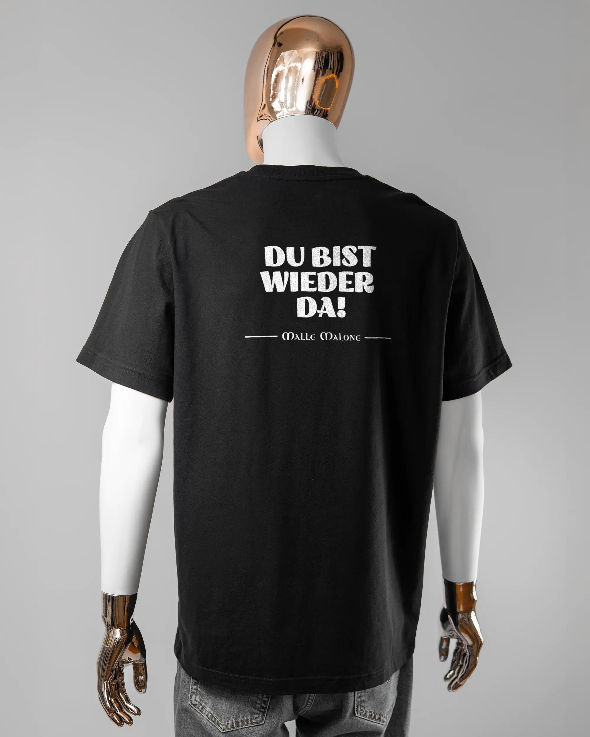 Rückseite des Organic Unisex T-Shirt Relaxed von Maondo mit dem Design Wieder da in der Farbe Black und in der Größe L getragen von einer maskulinen Puppe