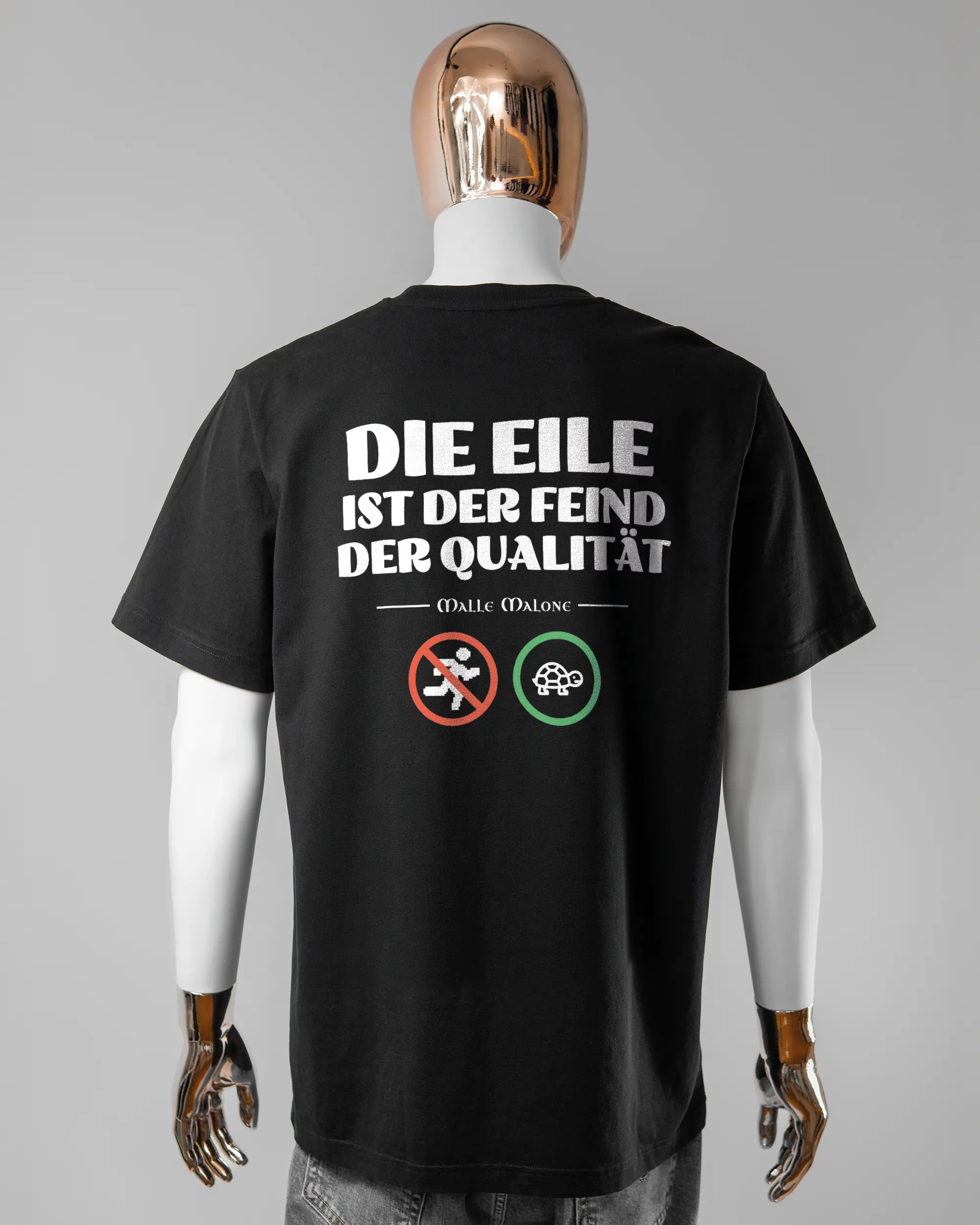 Rückseite des Organic Unisex T-Shirt Relaxed von Maondo mit dem Design Keine Eile in der Farbe Black und in der Größe L getragen von einer maskulinen Puppe