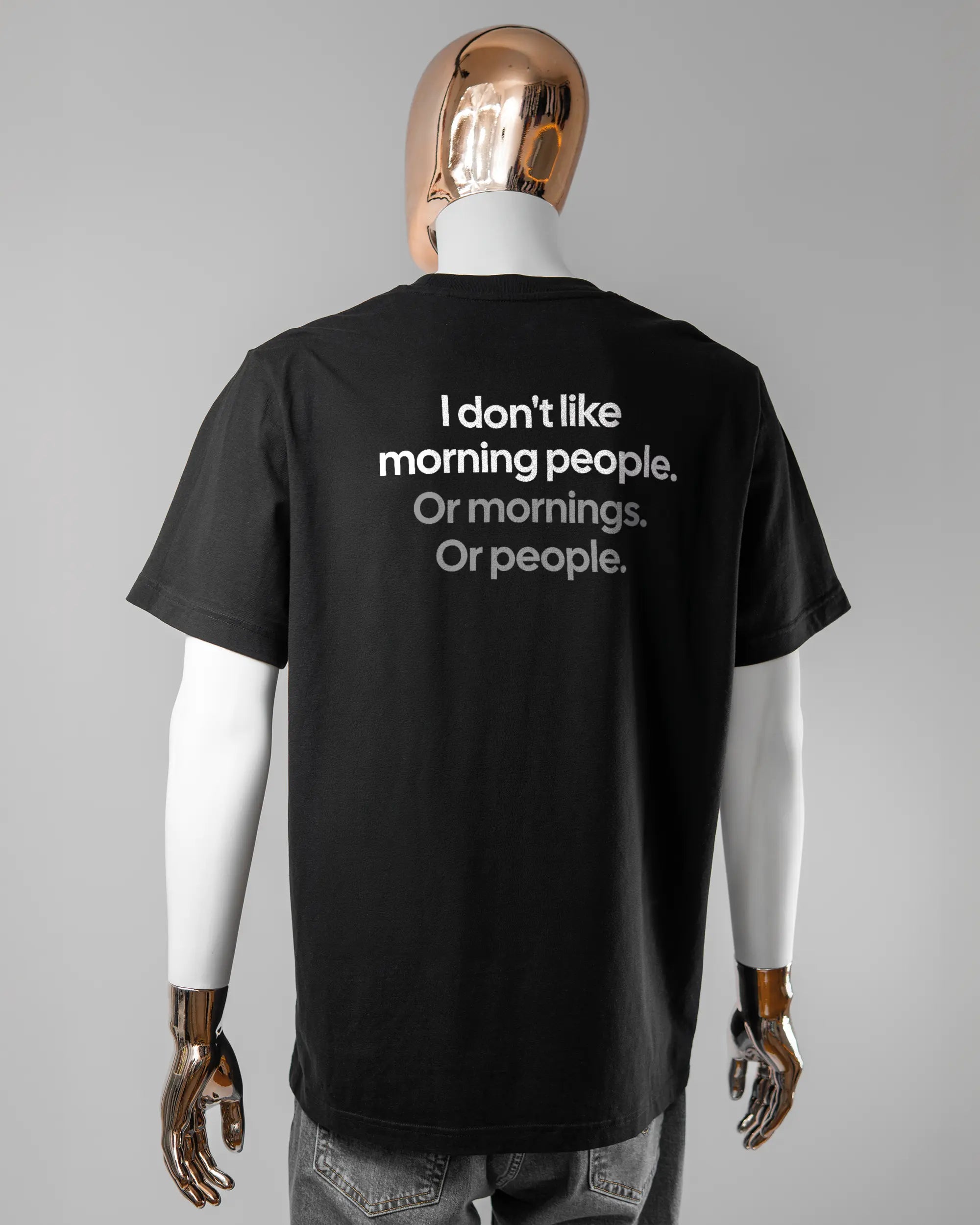 Rückseite des Organic Unisex T-Shirt Relaxed von Maondo mit dem Design Morning Person in der Farbe Black und in der Größe L getragen von einer maskulinen Puppe