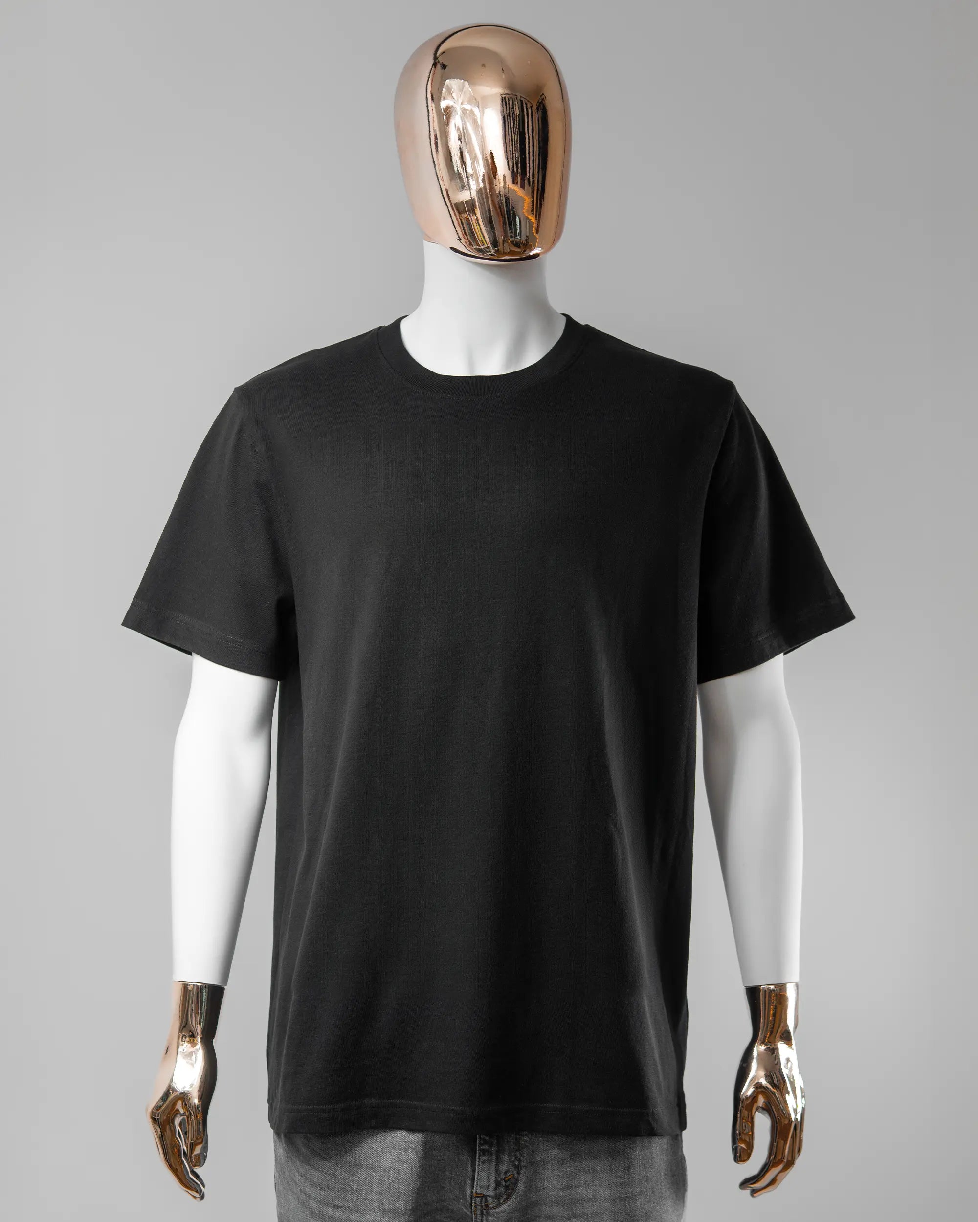 Vorderseite des Organic Unisex T-Shirt Relaxed von Maondo ohne Motiv in der Farbe Black und in der Größe L getragen von einer maskulinen Puppe