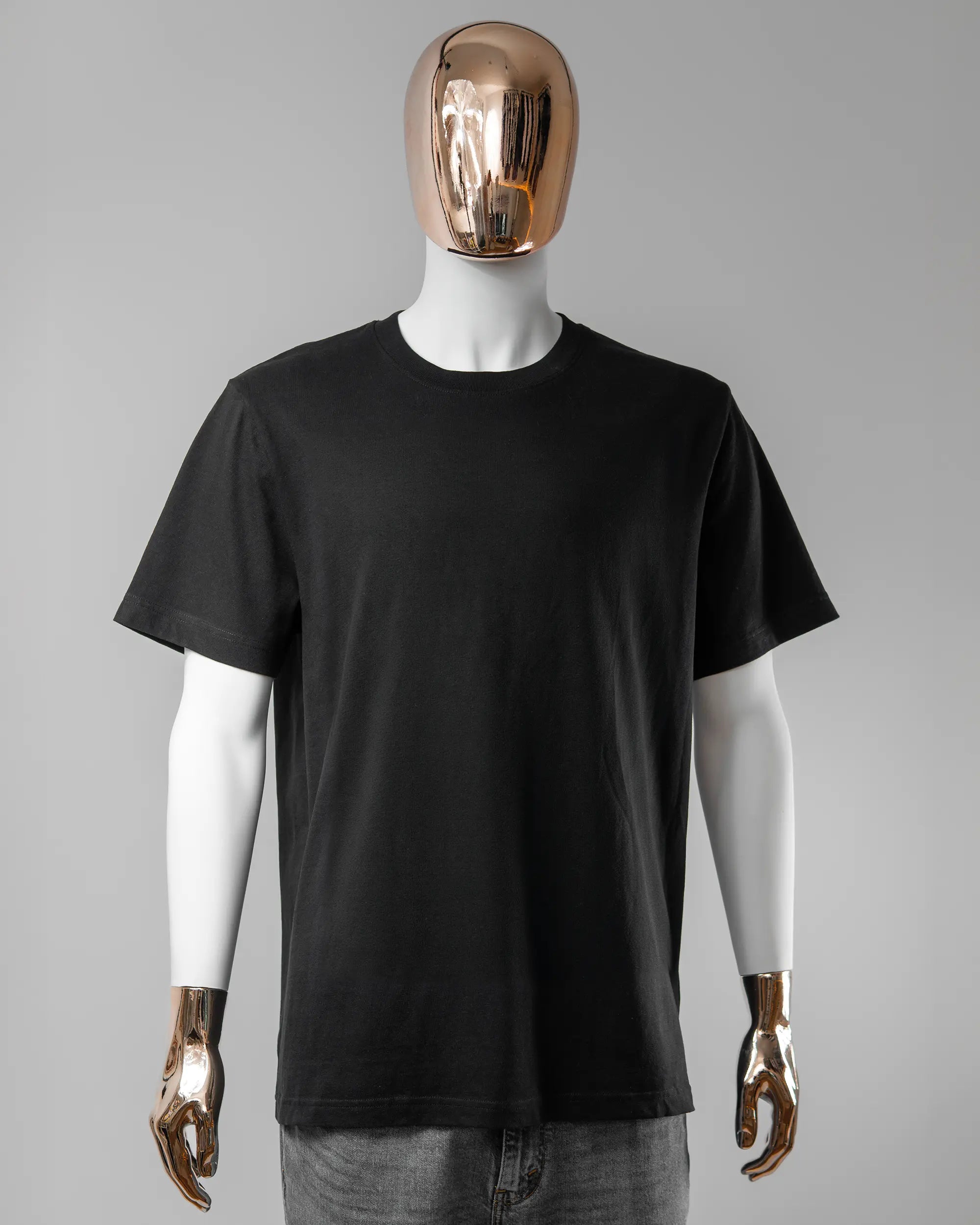 Vorderseite des Organic Unisex T-Shirt Relaxed von Maondo ohne Motiv in der Farbe Black und in der Größe L getragen von einer maskulinen Puppe