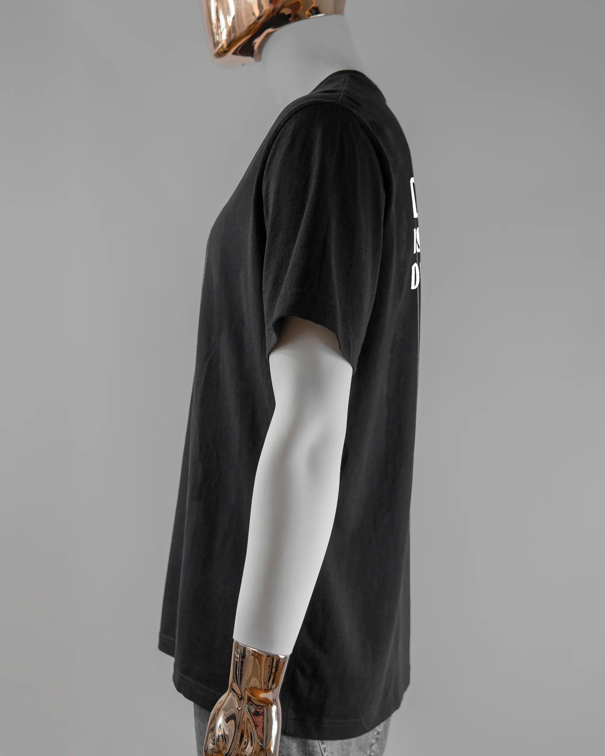 Seitenansicht des Organic Unisex T-Shirt Relaxed von Maondo mit dem Design Keine Eile hinten in der Farbe Black und in der Größe L getragen von einer maskulinen Puppe