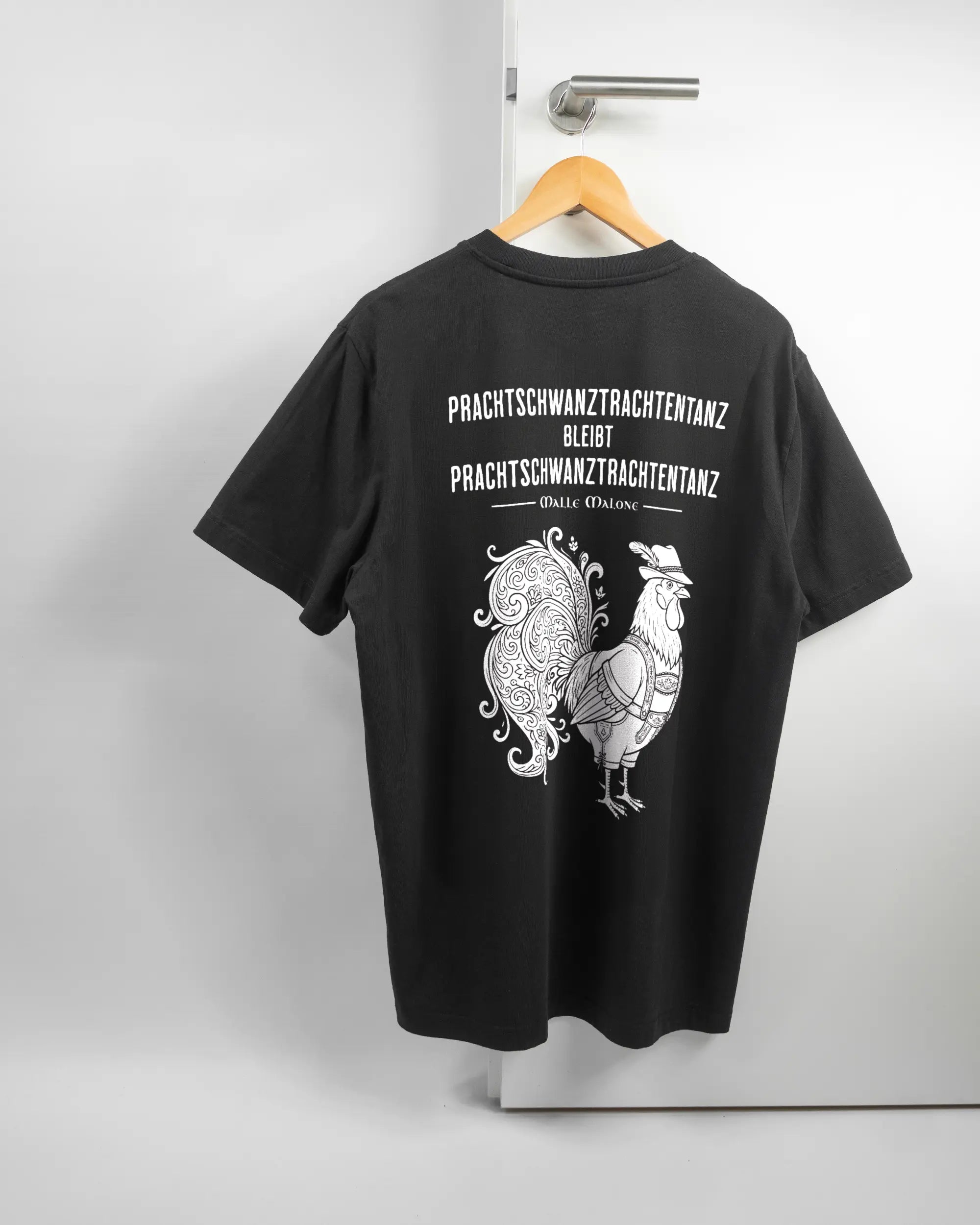 Rückseite des Organic Unisex T-Shirt Relaxed von Maondo mit dem Design Trachtentanz in der Farbe Black und in der Größe L auf einem Bügel an der Türklinke aufgehängt