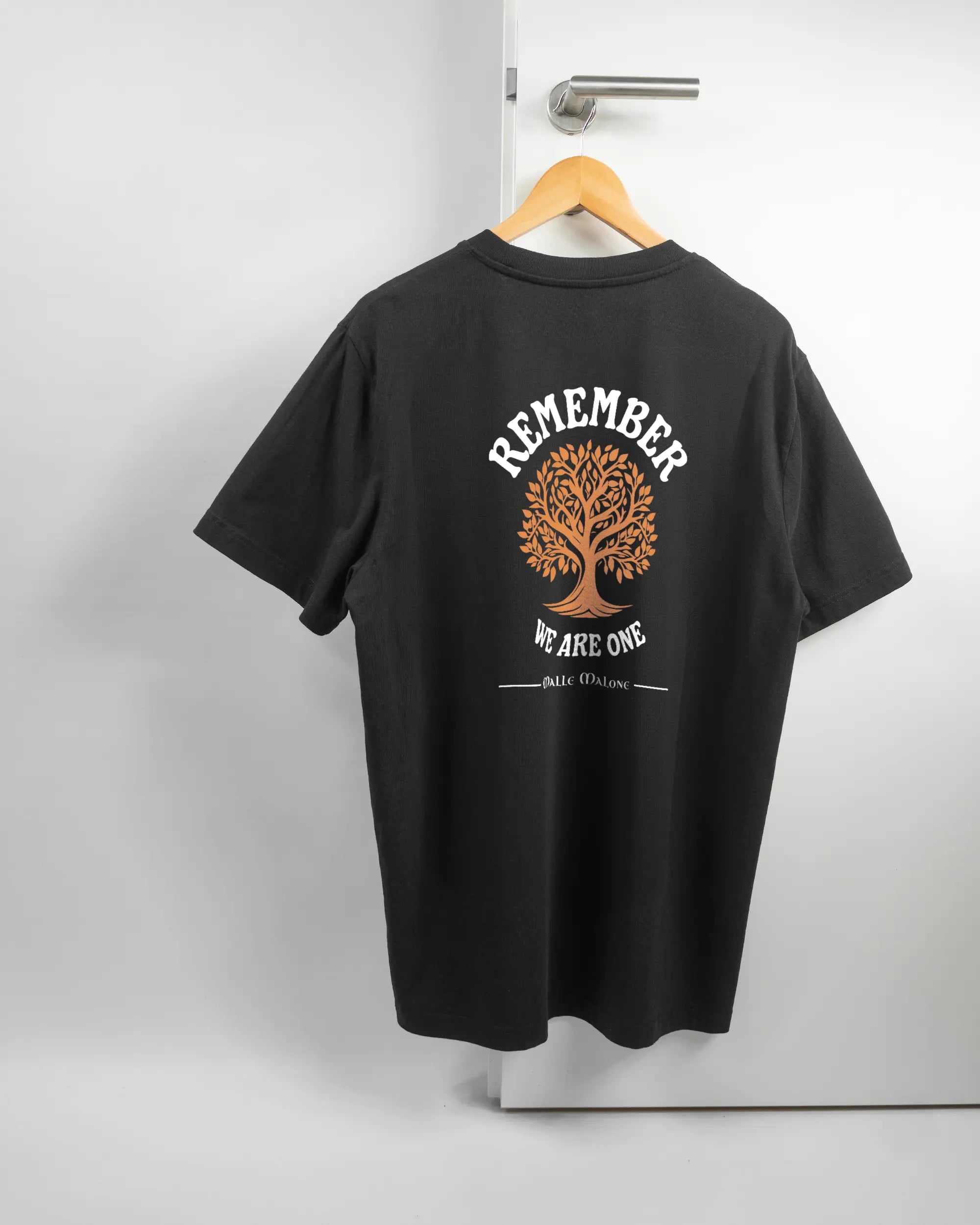 Rückseite des Organic Unisex T-Shirt Relaxed von Maondo mit dem Design We are one in der Farbe Black und in der Größe L auf einem Bügel an der Türklinke aufgehängt
