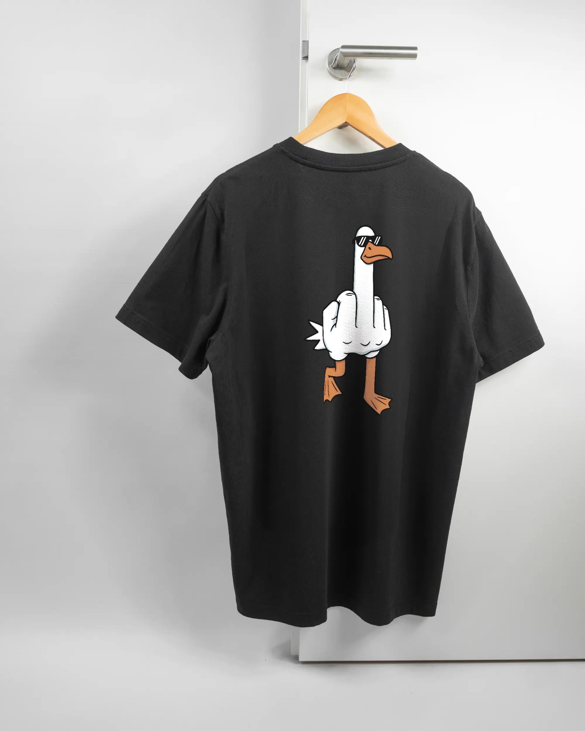 Rückseite des Organic Unisex T-Shirt Relaxed von Maondo mit dem Design I give a duck in der Farbe Black und in der Größe L auf einem Bügel an der Türklinke aufgehängt