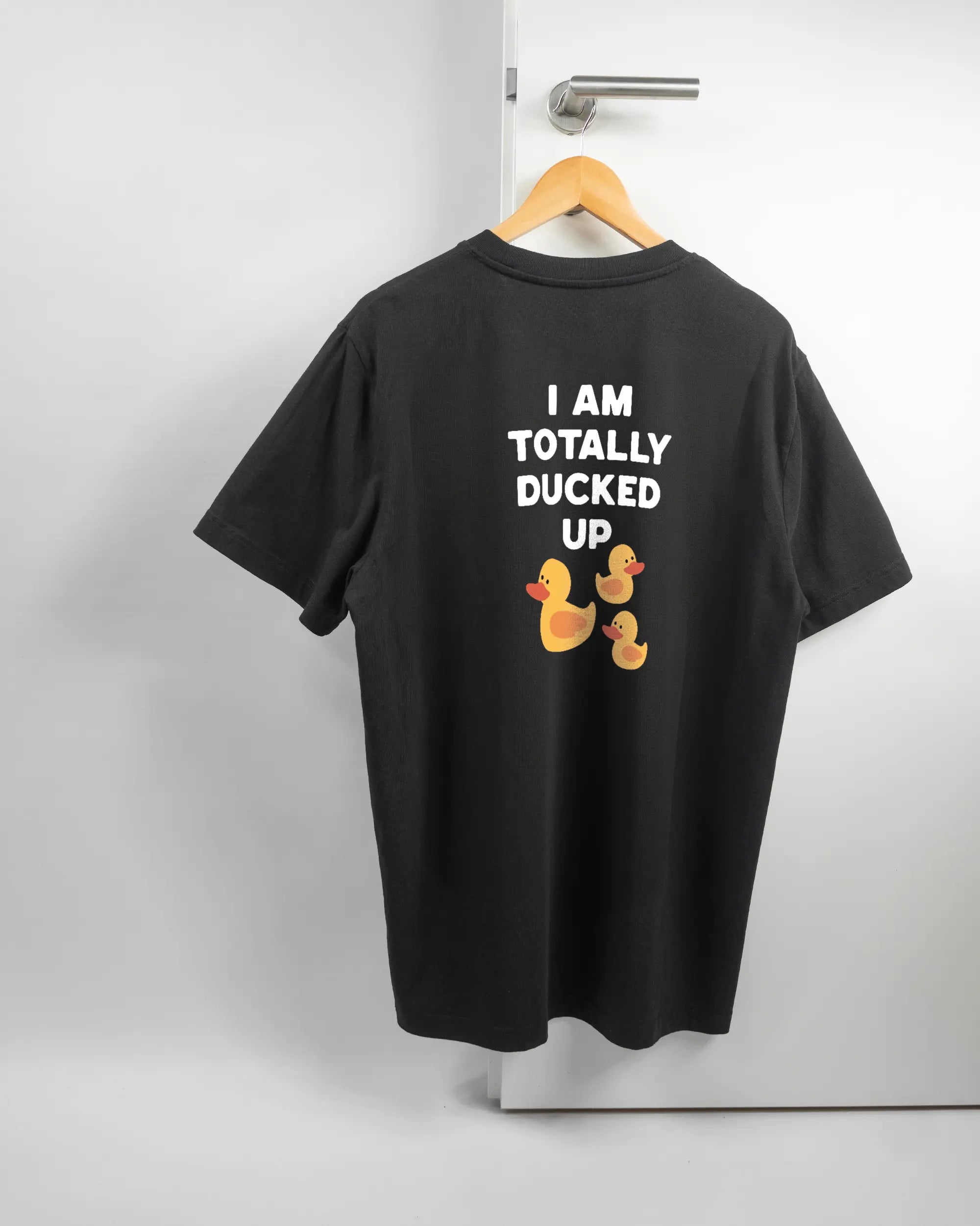 Rückseite des Organic Unisex T-Shirt Relaxed von Maondo mit dem Design Ducked Up in der Farbe Black und in der Größe L auf einem Bügel an der Türklinke aufgehängt