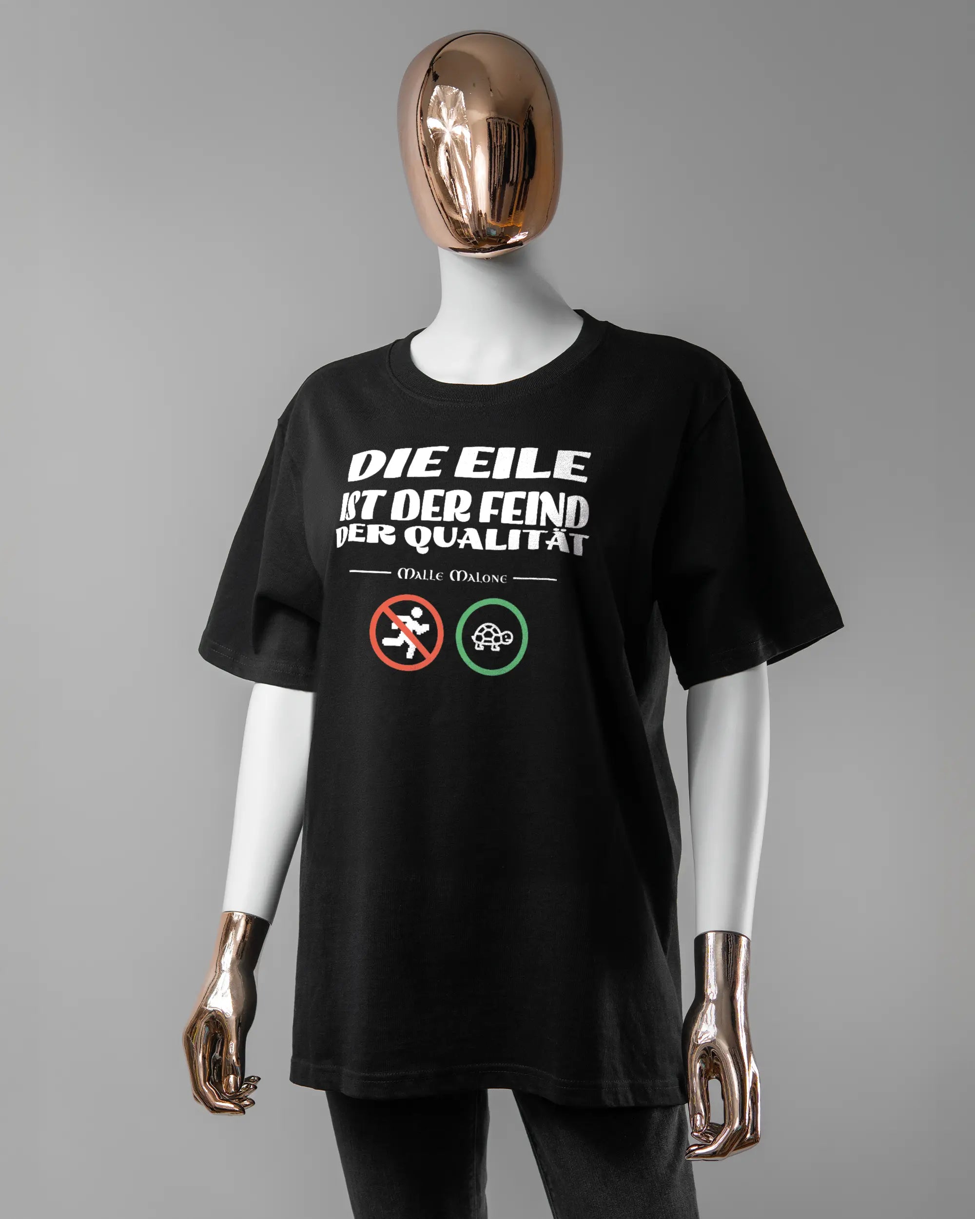 Vorderseite des Organic Unisex T-Shirt Relaxed von Maondo mit dem Design Keine Eile in der Farbe Black und in der Größe S getragen von einer femininen Puppe